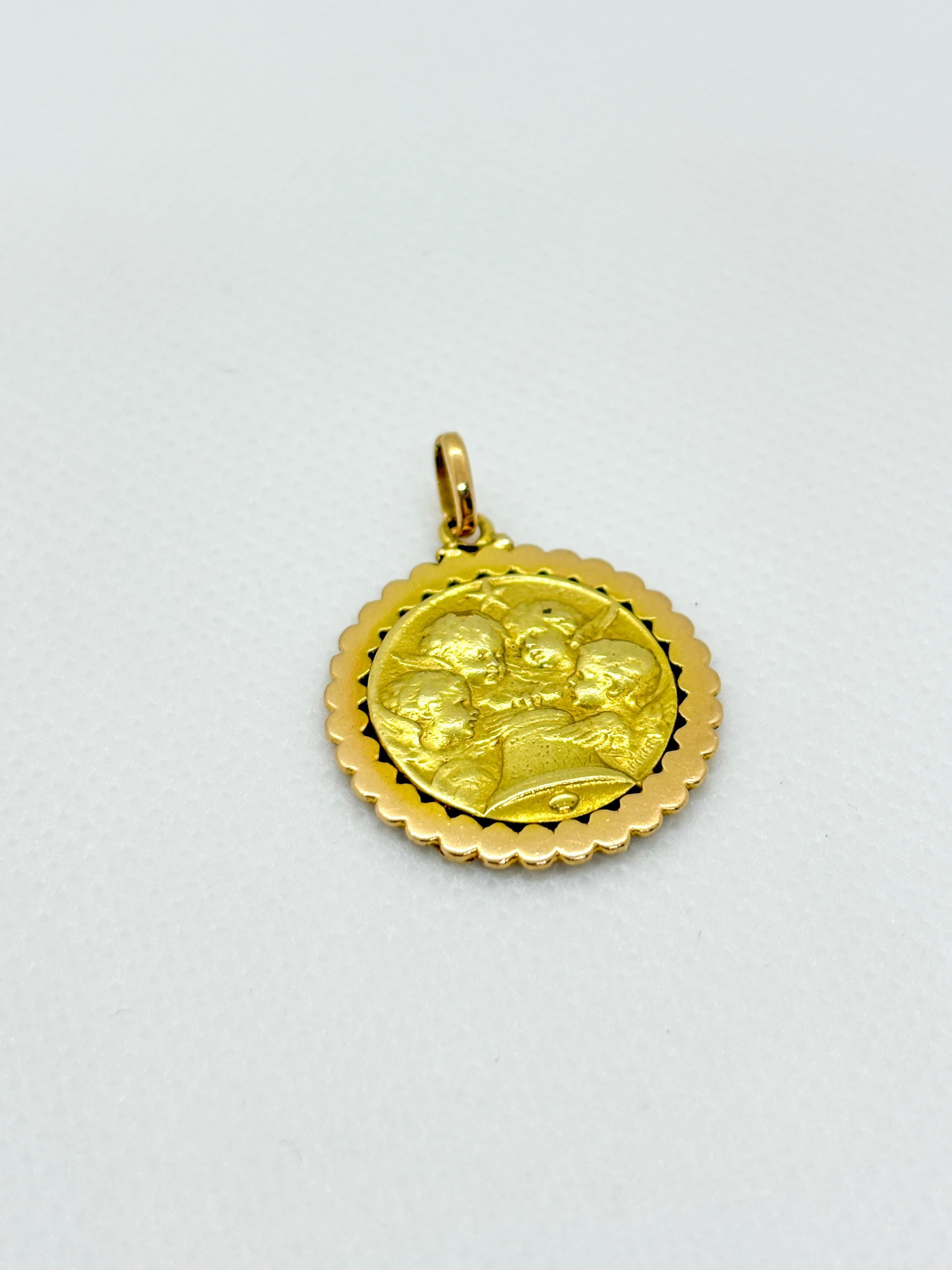 Squisita medaglia d'epoca in oro giallo 18 carati raffigurante tre angeli custodi riuniti intorno a una campana sotto una piccola stella - un motivo Angelus attribuito al medaglista francese Hédmond Henri Becker (1871-1942). Questo pezzo finemente