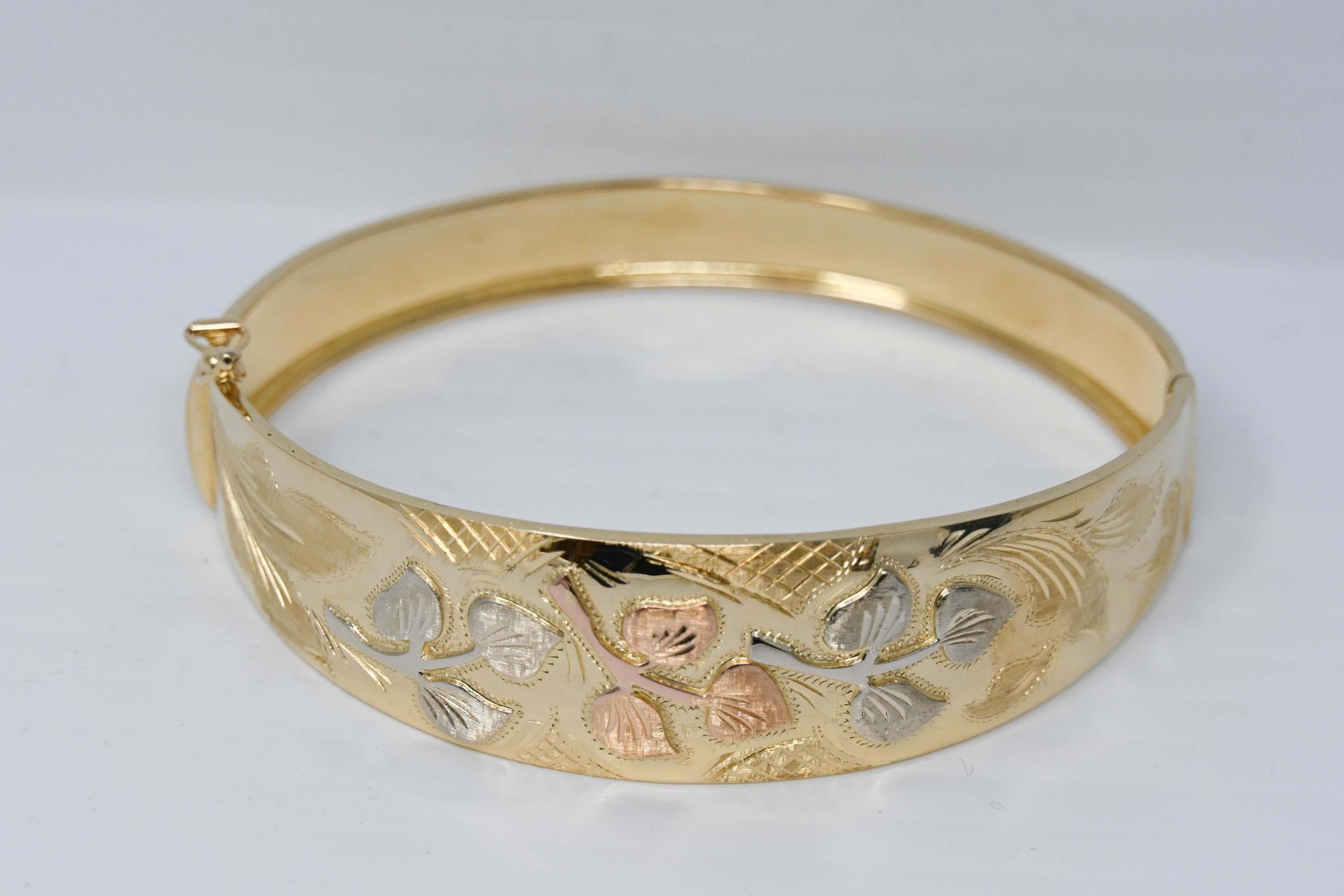 Vintage 18k yellow gold bangle bracelet with leaf design. Made in Italy, stamped 18k and maker mark weighs 31.1. Measures 2 1/2 inches x 3 inches and 7/8 inches wide at the top.
