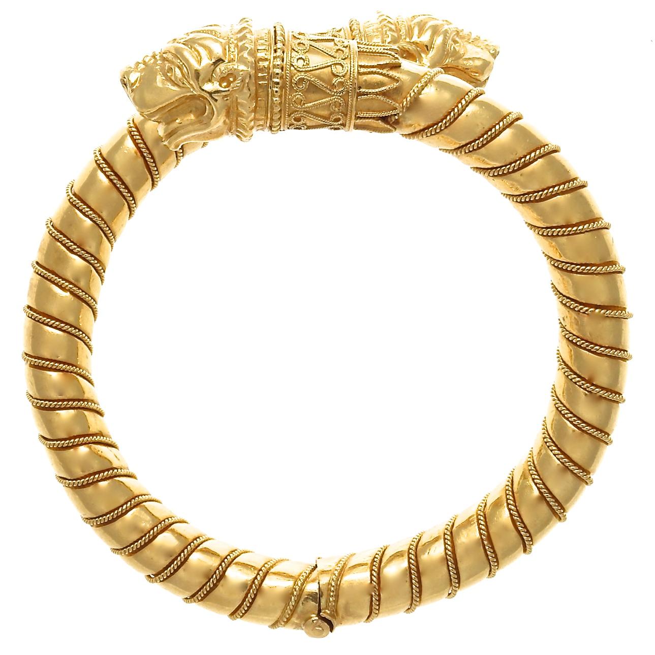 A luxurious 18k gold bangle with ornamental dog head ends that wrap around the wrist. The perfect addition to your wrist stack, adding the opulence of pure gold with a unique design. 48.9 grams. Inside dimensions measure 2-1/8 inches x 2 inches. 