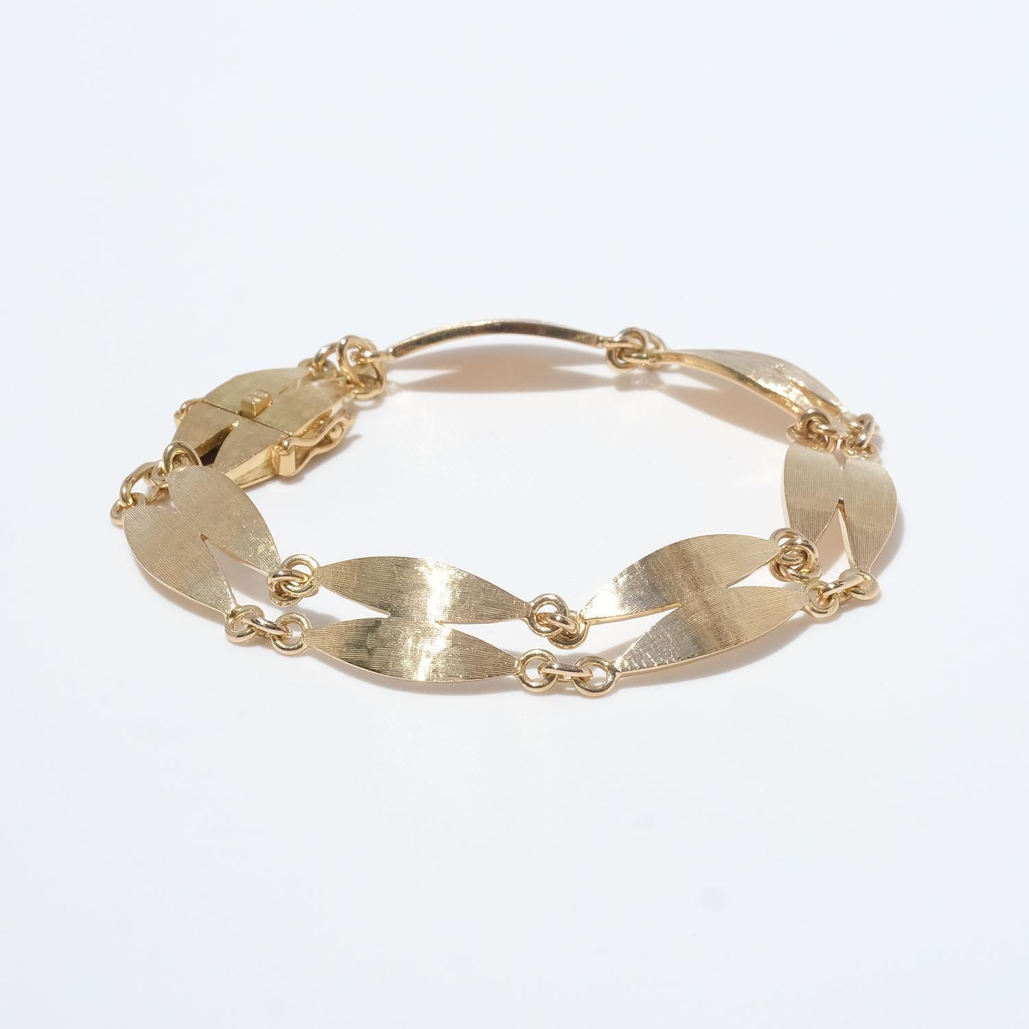 Dieses Armband aus 18 Karat Gold besteht aus ovalen Doppelgliedern, die mit kleinen Goldringen verbunden sind. Die Glieder haben eine matte und gebürstete Oberfläche. Das Armband lässt sich leicht mit einem Kastenverschluss schließen.

Das Armband