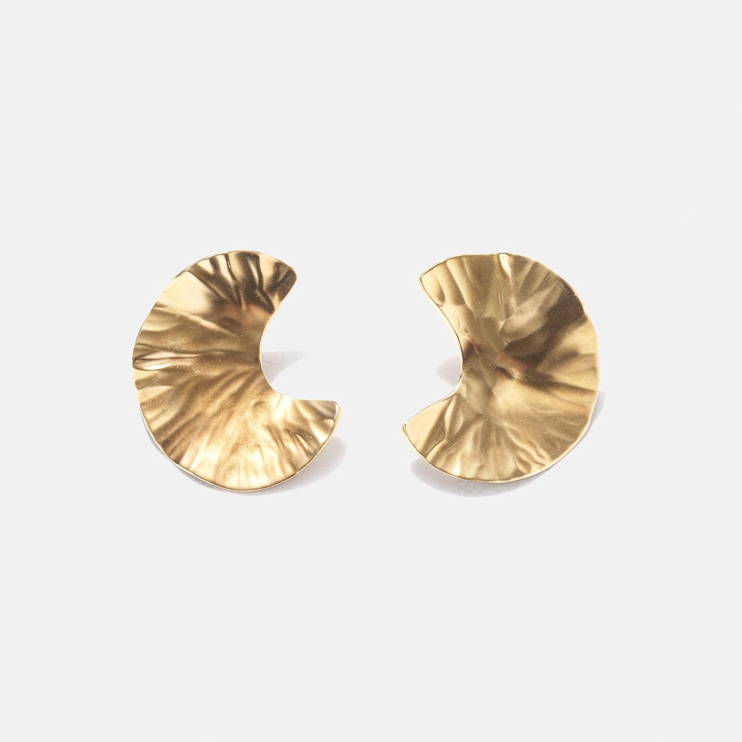 These 18 karat earrings have a unique, curved shape that resembles wavy leaves or small fans. The surface is textured with soft, rippled patterns that catch the light, giving them a vibrant, shimmering appearance. They are clip-on earrings, which