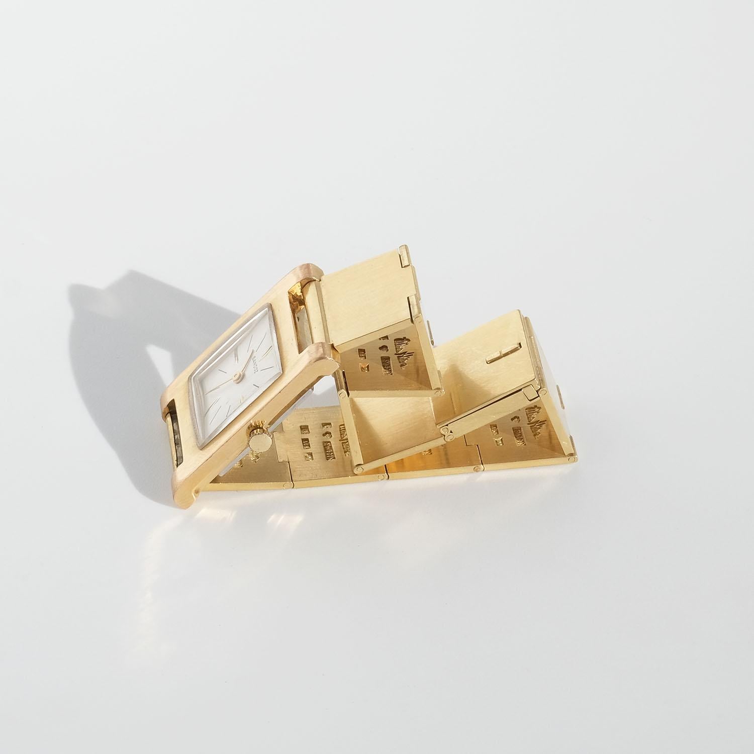 Dieses 18-karätige Gold-Uhrenglied besteht aus elf quadratischen Platten aus 18-karätigem Gold, die miteinander verbunden sind. Wenn Sie das Uhrenglied umdrehen, können Sie sehen, dass jede Goldplatte mit mehreren schwedischen Zeichen versehen ist,