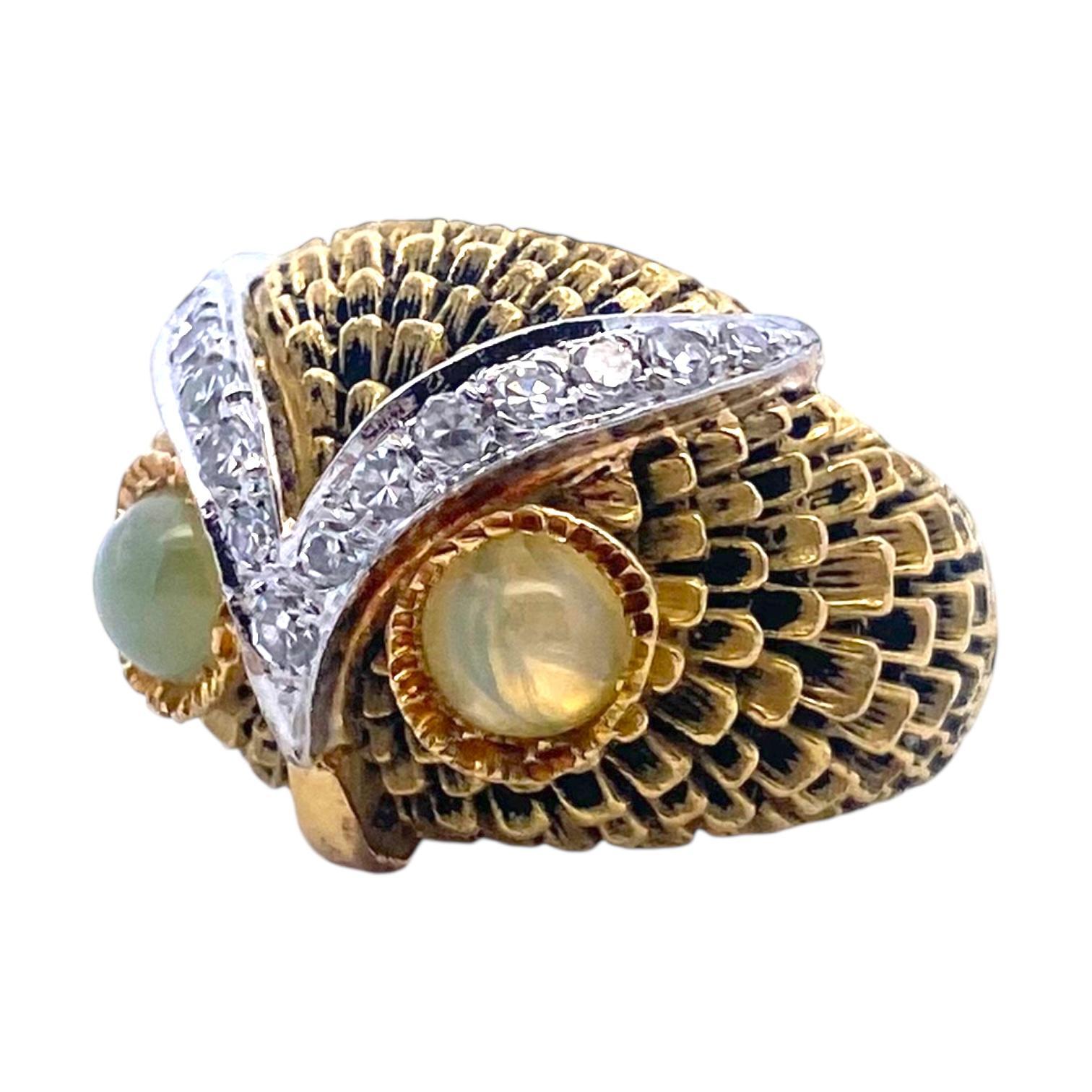 Anello d'epoca in oro 18 carati con un sorprendente design a forma di gufo, caratterizzato da occhi di crisoberillo verde chiaro accentuati da sopracciglia luminose con diamanti bianchi e piume in oro giallo 18 carati. 
Misure:
Larghezza: 17 mm