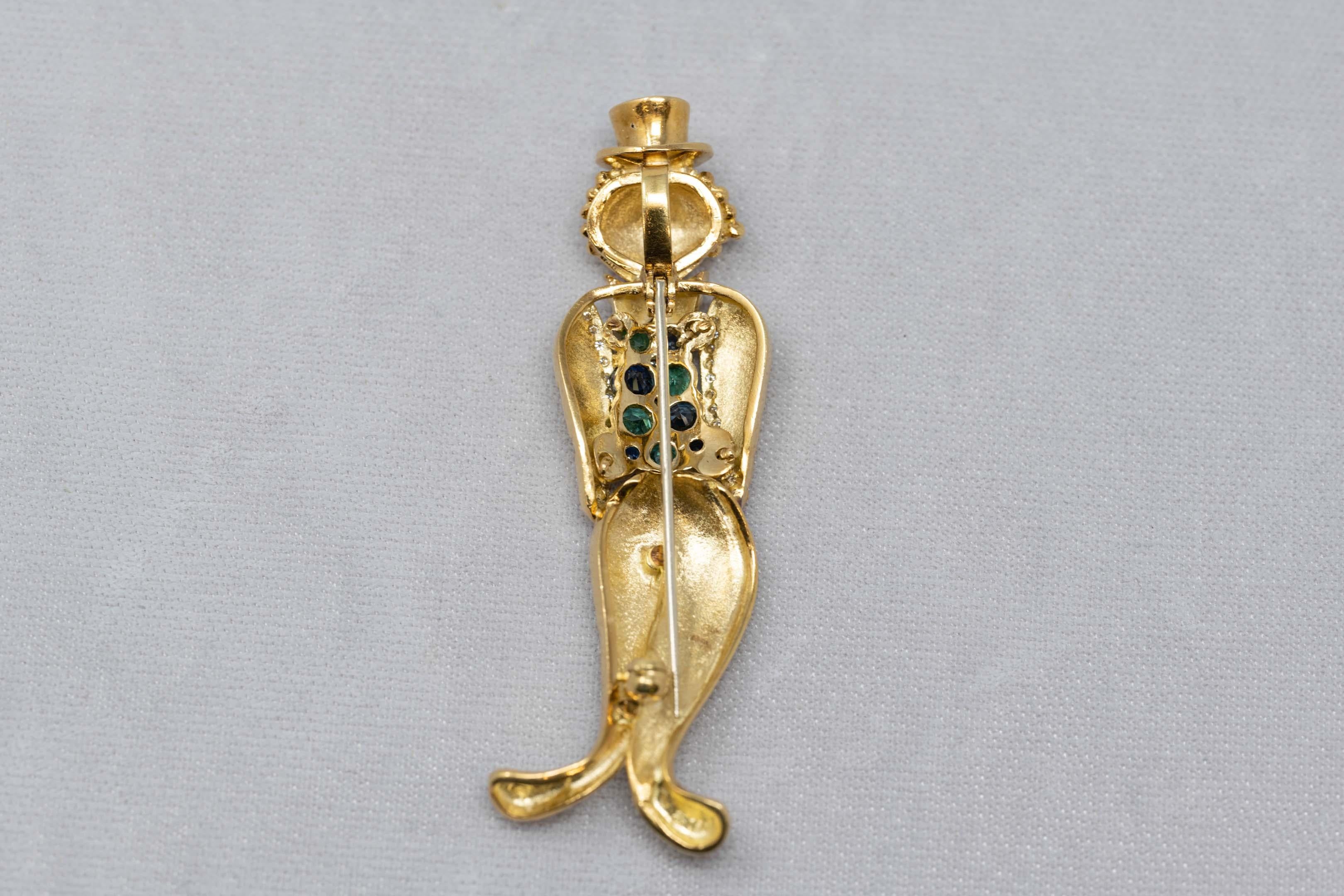 18k yellow gold clown brooch set with 29 diamonds for a total weight of .30ct plus 5 emeralds and 5 sapphires. Measures 2 5/8 inches tall. Stamped 750 and HB for maker mark. Weighs 17 grams.
