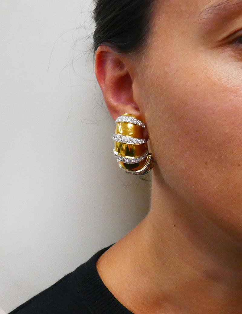         A pair of vintage hoop earrings, made of 18 karat gold and set with diamond. A great piece from our estate jewelry collection.
	Large and notable gold hoop earrings with a bright gold color that makes diamonds pop. 
	The diamond staged in
