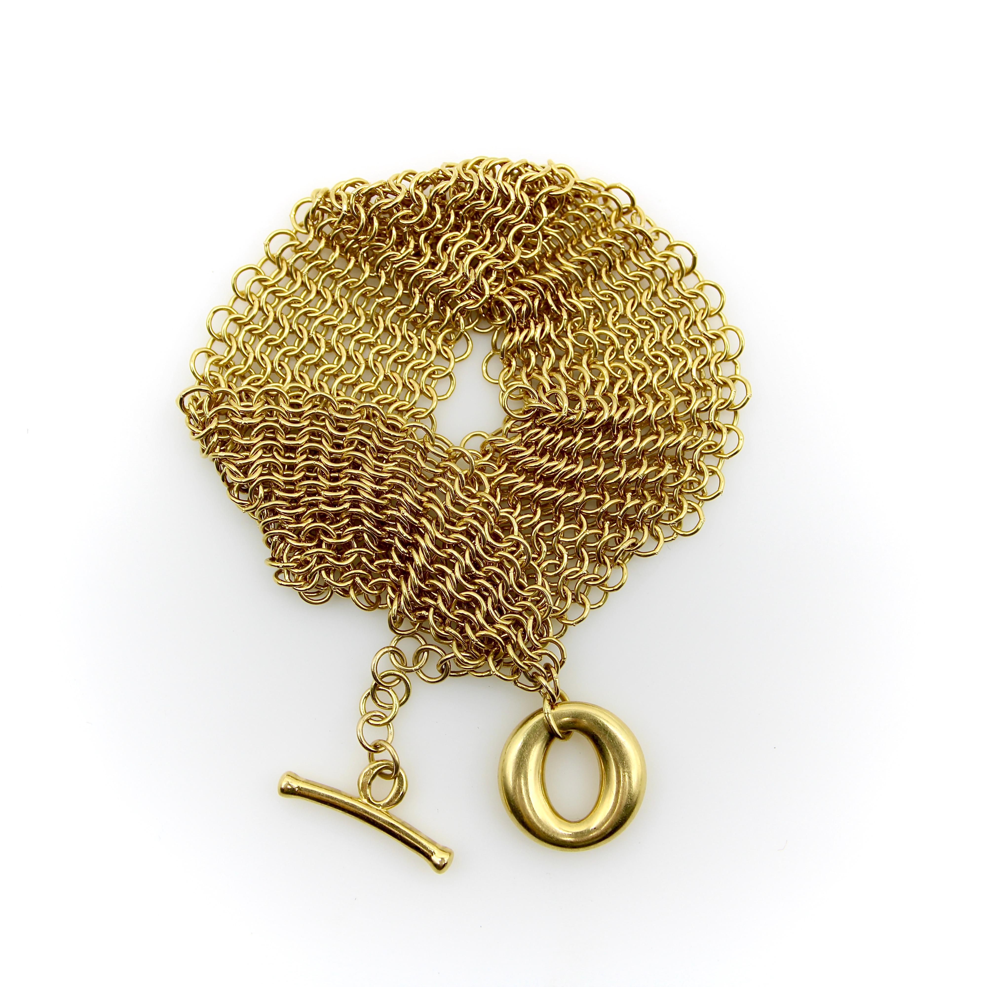 Designed by Elsa Peretti for Tiffany & Co., this 18k gold Somerset bracelet is a gorgeous, fluid piece that drapes elegantly around the wrist. Layers of circular gold links are interwoven to create golden mesh that is reminiscent of medieval