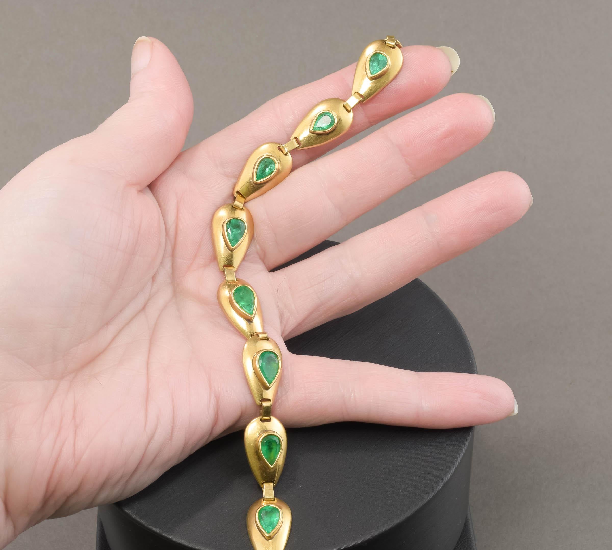 Offered is a very striking and unusual vintage Emerald Bracelet composed of ten 18K gold teardrop shaped links, each bezel-set with a vividly colored natural emerald.  The bracelet retains both its original hallmarked slide in clasp and safety