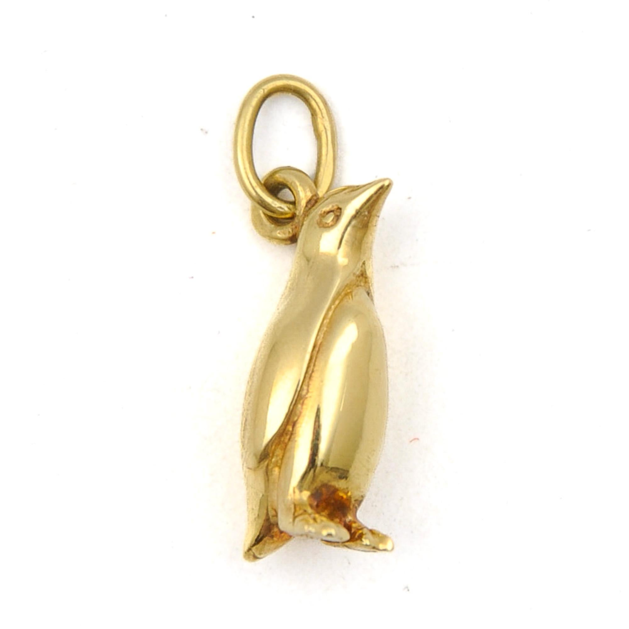 A three-dimensional stylized and detailed penguin charm pendant. This adorable emperor penguin has beautiful details with a round belly, little feet, wings, beak and a tail. This elegant arctic creature is made in solid 18 karat gold. 

Penguins