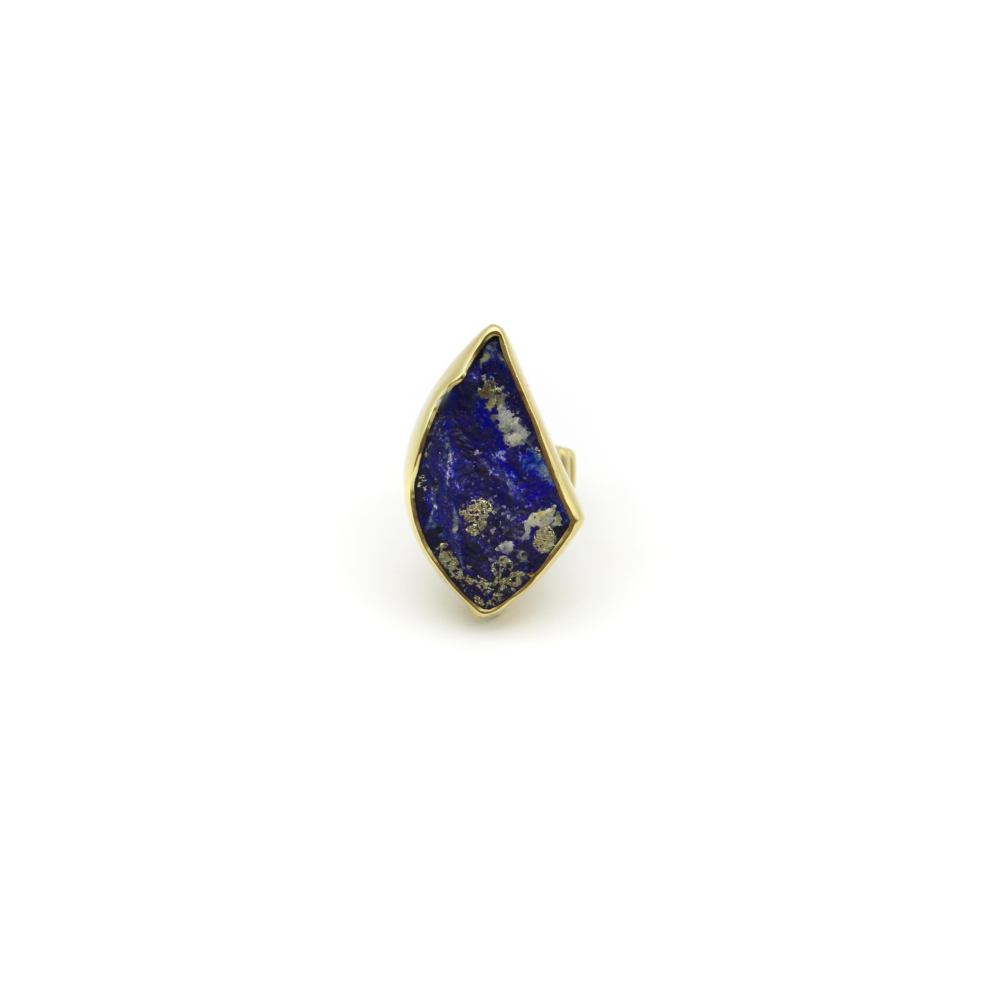 A bold statement piece that features a rough cut deep saturated blue Lapis Lazuli specimen. In its raw form, the stone has sparkling flecks of pyrite and calcite that are a striking contrast against the rich blue. Lapis Lazuli is an aggregate of