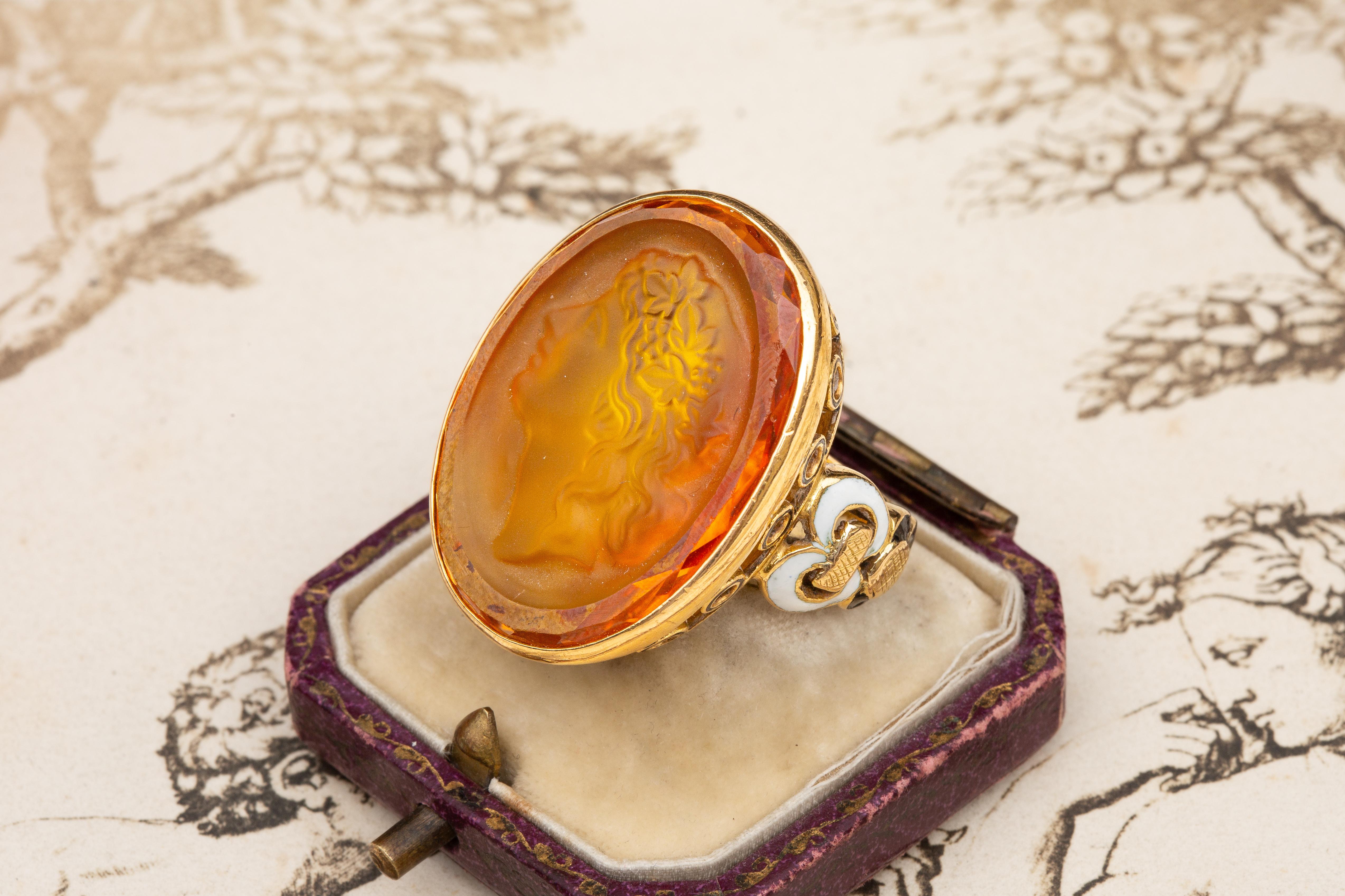 A superb and unusual glass cameo ring made in Paris, circa 1960. The ring is rather large in scale, crafted in 18K gold and weighing a seriously impressive 29 grams. In the centre rests a bright orange “pate de verre” (moulded glass paste) cameo