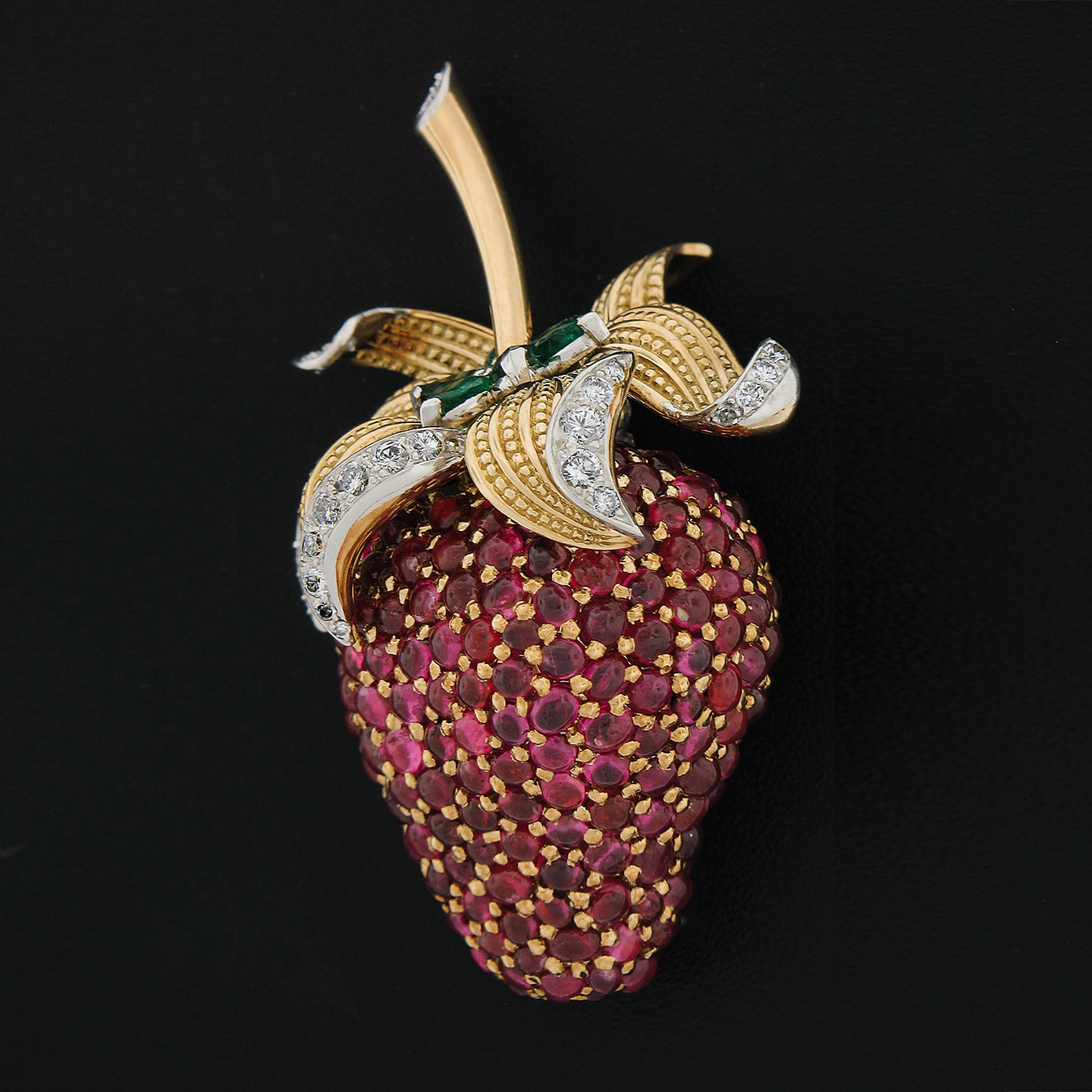 This truly magnificent vintage brooch that is very well crafted in solid yellow gold and platinum, features a truly jaw dropping strawberry design that is completely covered with top quality Burma rubies, emerald and diamonds throughout. Two of the