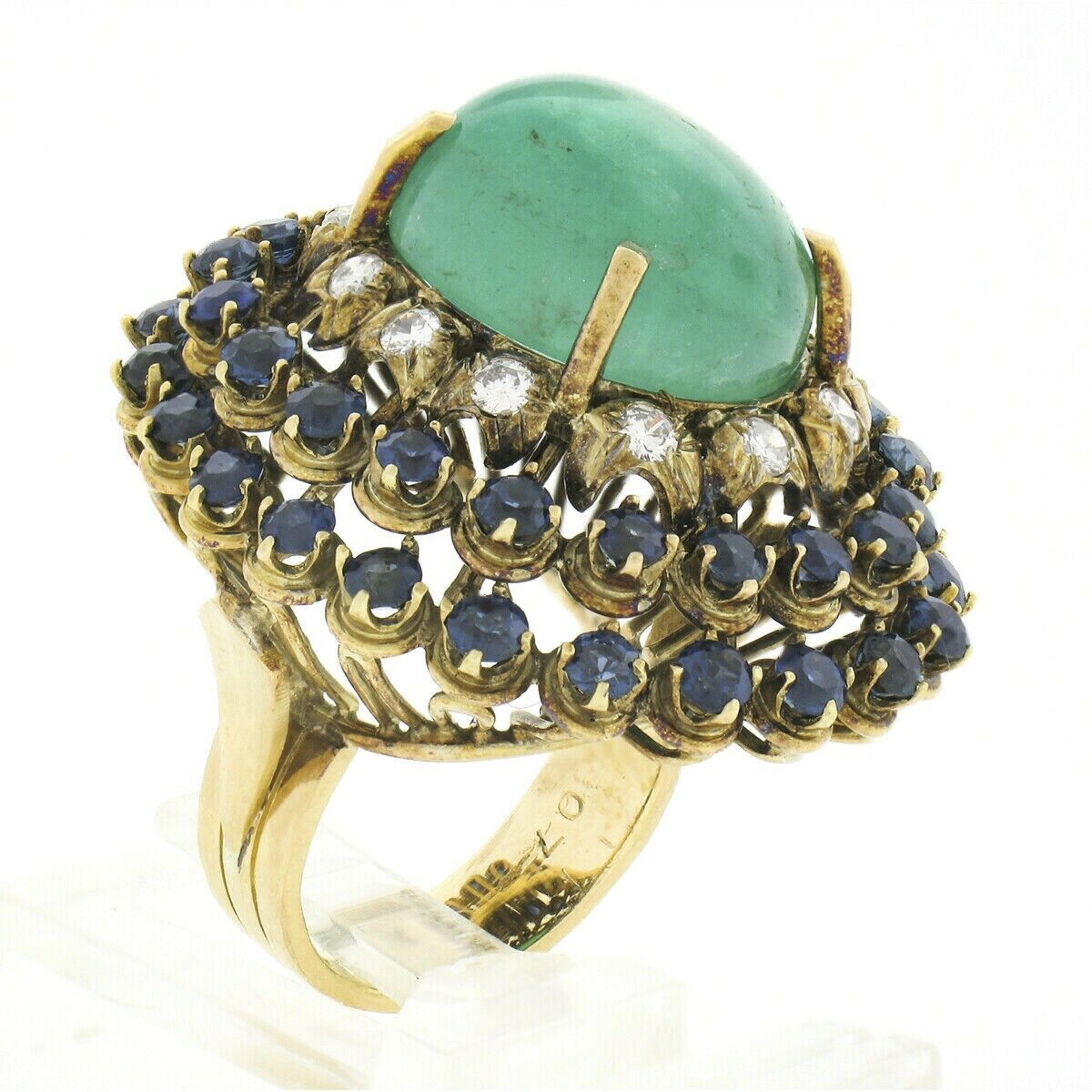 You are looking at a truly fine and breathtaking, GIA certified emerald, sapphire and diamond vintage cocktail ring crafted in solid 18k yellow gold. This very large and showy ring features a fine quality, high-domed, oval cabochon cut emerald