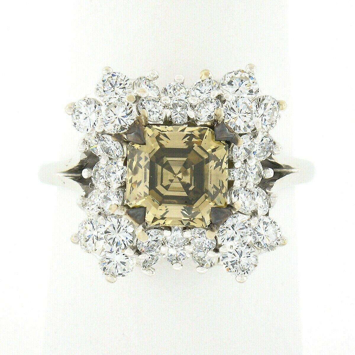 This gorgeous vintage diamond cocktail or engagement style ring is crafted in solid 18k white gold and features an amazing, 1.82 carat, GIA certified square emerald cut diamond neatly prong set at its center. The center stone has a natural, fancy