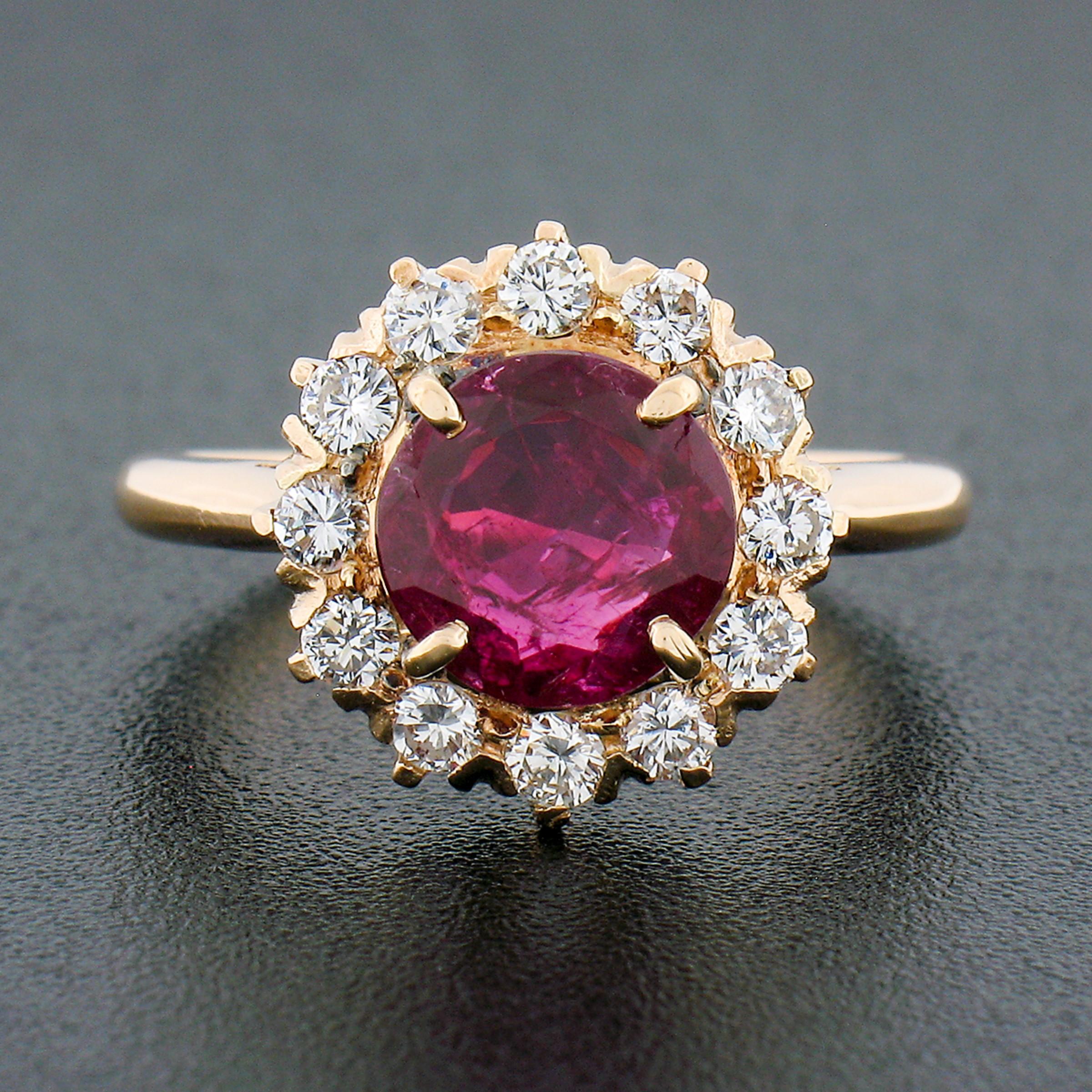 You are looking at an absolutely stunning vintage ring crafted in solid 18k yellow gold featuring an elegant flower cluster style with a gorgeous ruby stone neatly prong set at the center of the brilliant diamond halo. The magnificent ruby has been