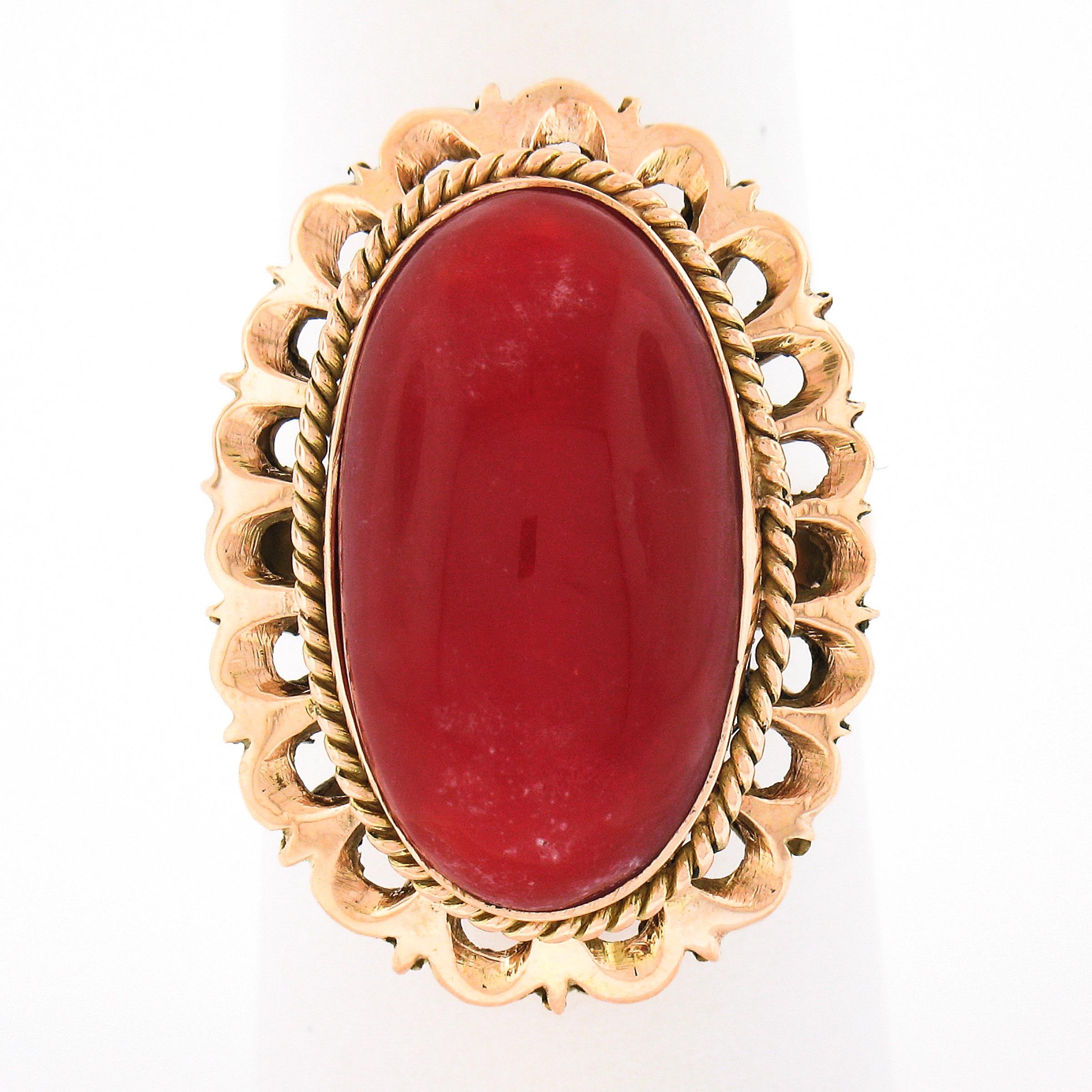 Here we have an absolutely beautiful vintage ring that is crafted from solid 18k gold featuring a fine coral stone neatly bezel set at its center. This elongated oval cabochon coral is GIA certified, showing a truly gorgeous and intense orangy-red