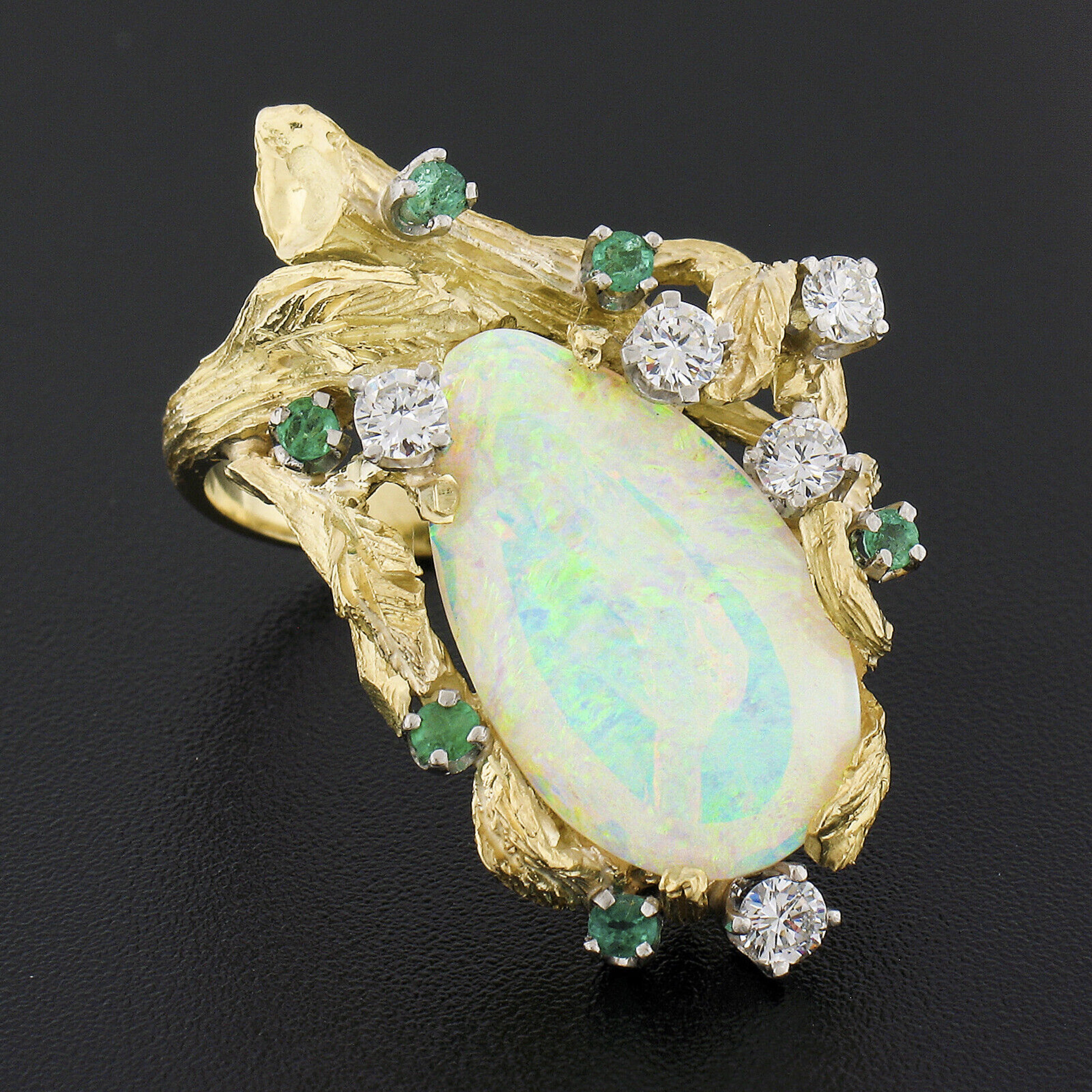 Here we have a unique vintage cocktail ring that was crafted from solid 18k yellow gold. This large and beautiful ring displays a lovely open work design with nice bark textured finish throughout the top, and features a very fine opal solitaire with