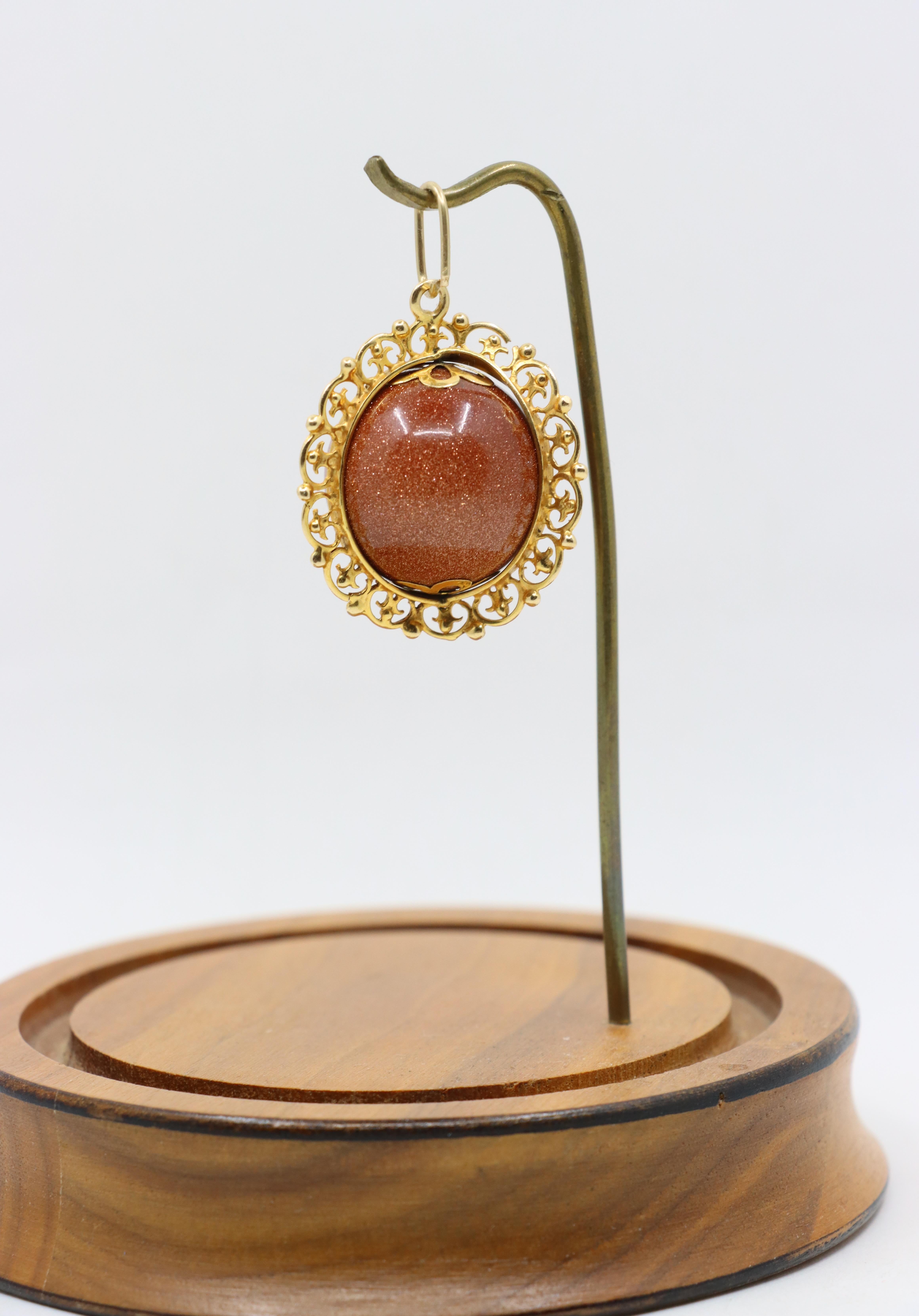 Ciondolo a forma di palla con cabochon in pietra d'oro d'epoca 18 carati

Dimensioni approssimative:
4,5 cm (lunghezza) 
2,8 cm (larghezza)
22,18 mm (Goldstone)
19,6 grammi di peso.