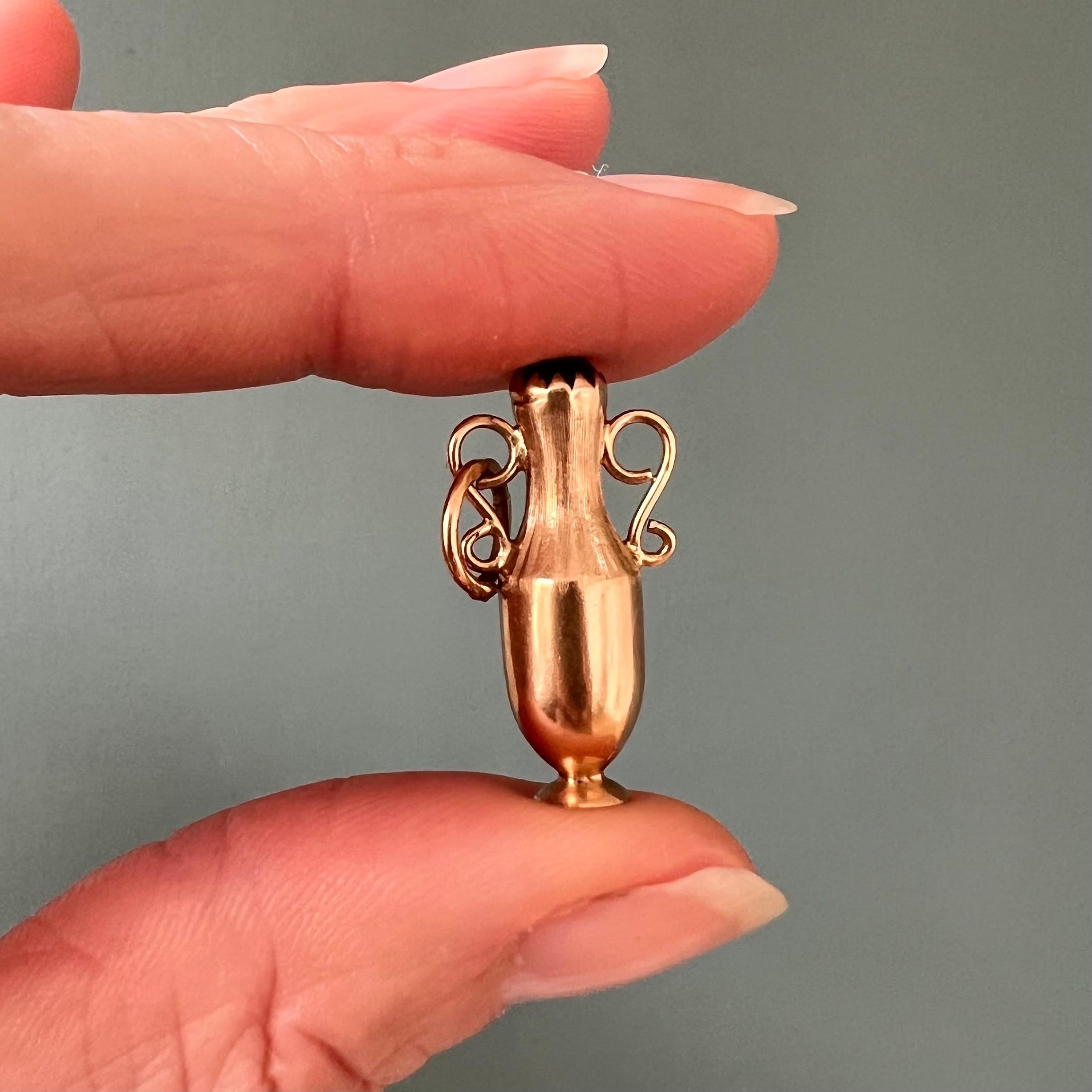 A lovely vintage 18 karat yellow gold Greek Amphora vase jug charm pendant. The charm is nicely modeled into an ancient Greek-style Amphora jug and set with a green stone at the top. The bottle neck has a matte satin finish while the lower part is