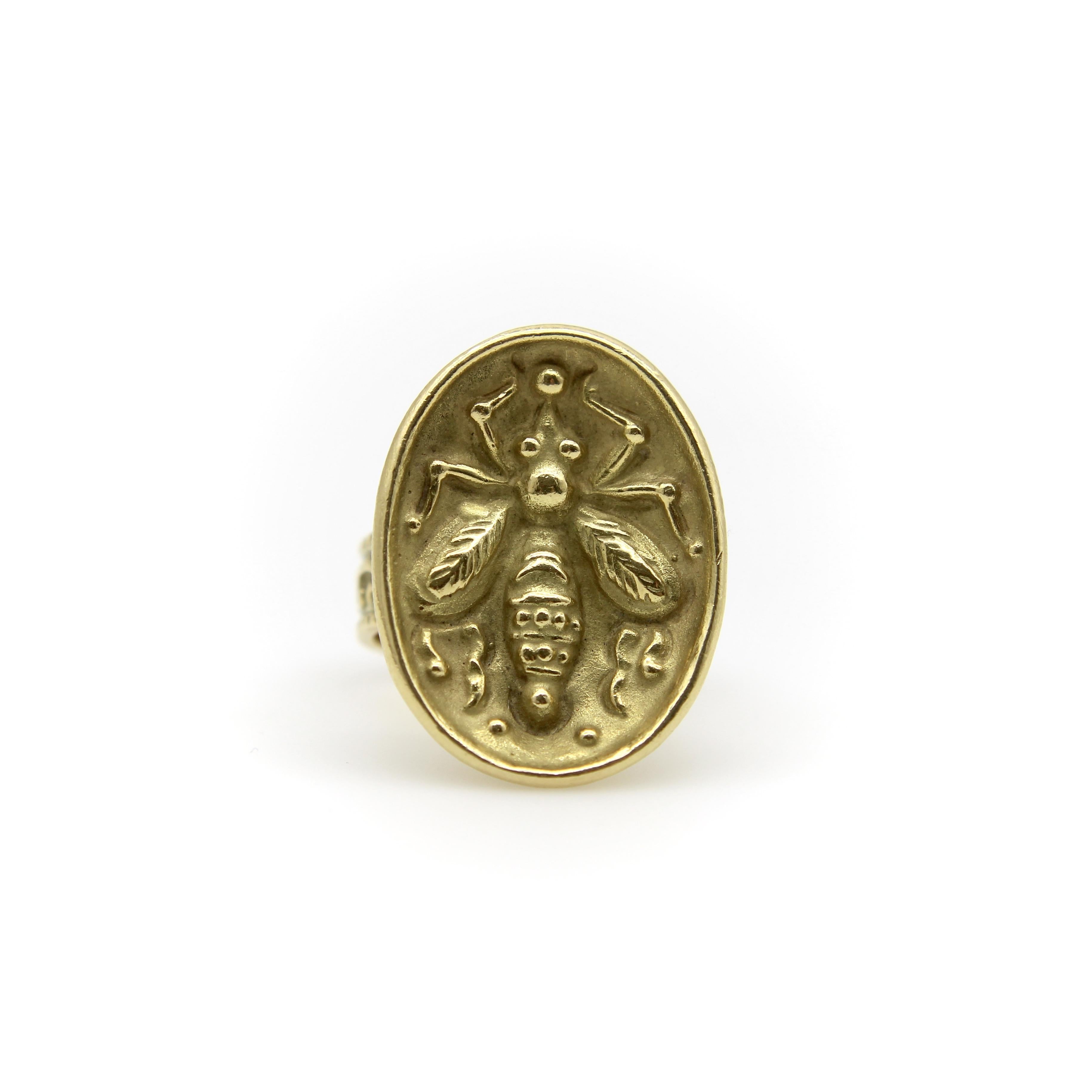 This 18k gold signet ring features a stylized cameo of a honey bee in a shallow concave oval. This iconic Greek symbol is beautifully depicted in bas relief with accentuated details on the bee's elongated body. The gold has a lovely patina; the