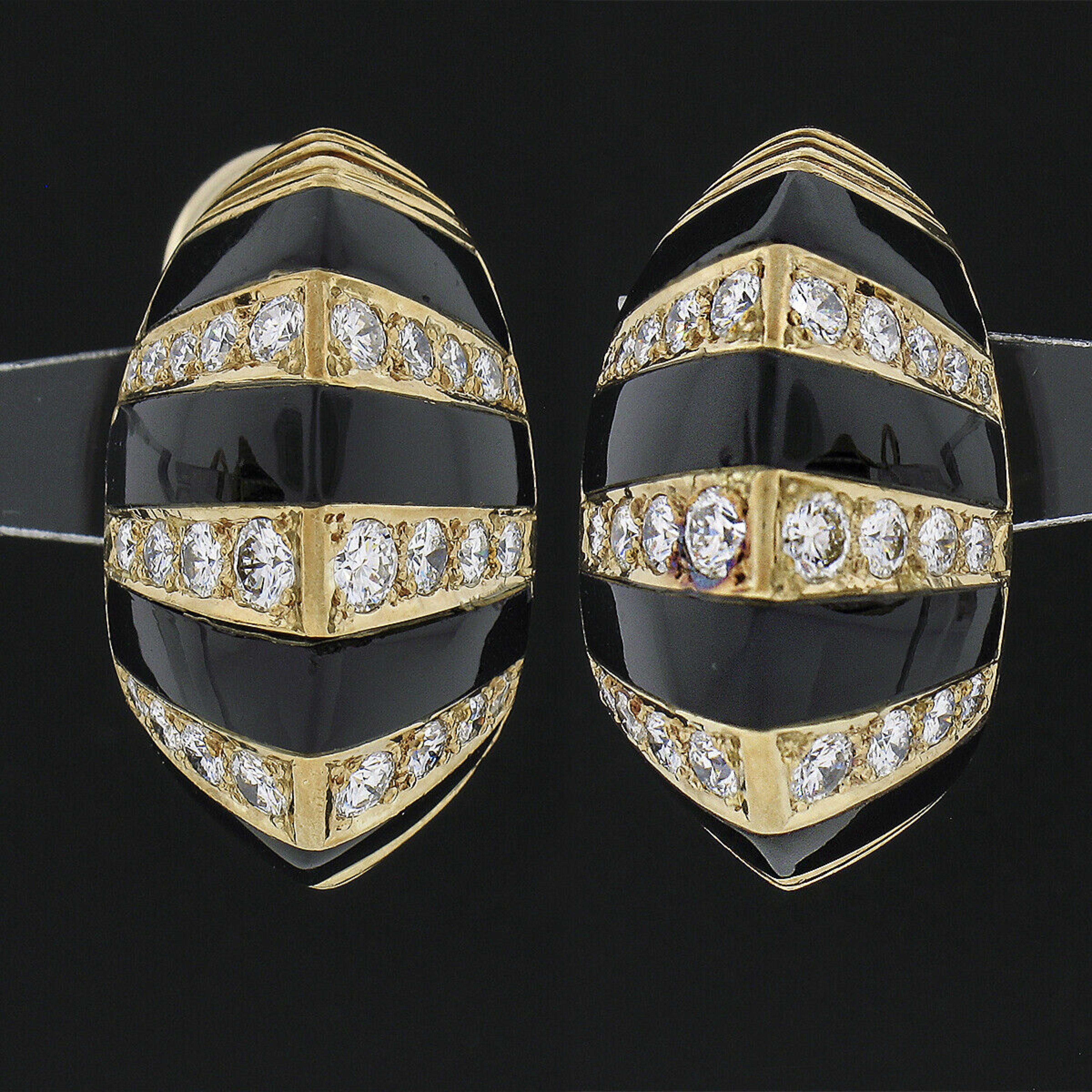 These outstanding vintage earrings are crafted in solid 18k yellow gold and feature a domed button style that alternates with fine black onyx gemstones and diamonds throughout. Their elegant striped design is constructed from custom cut black onyx