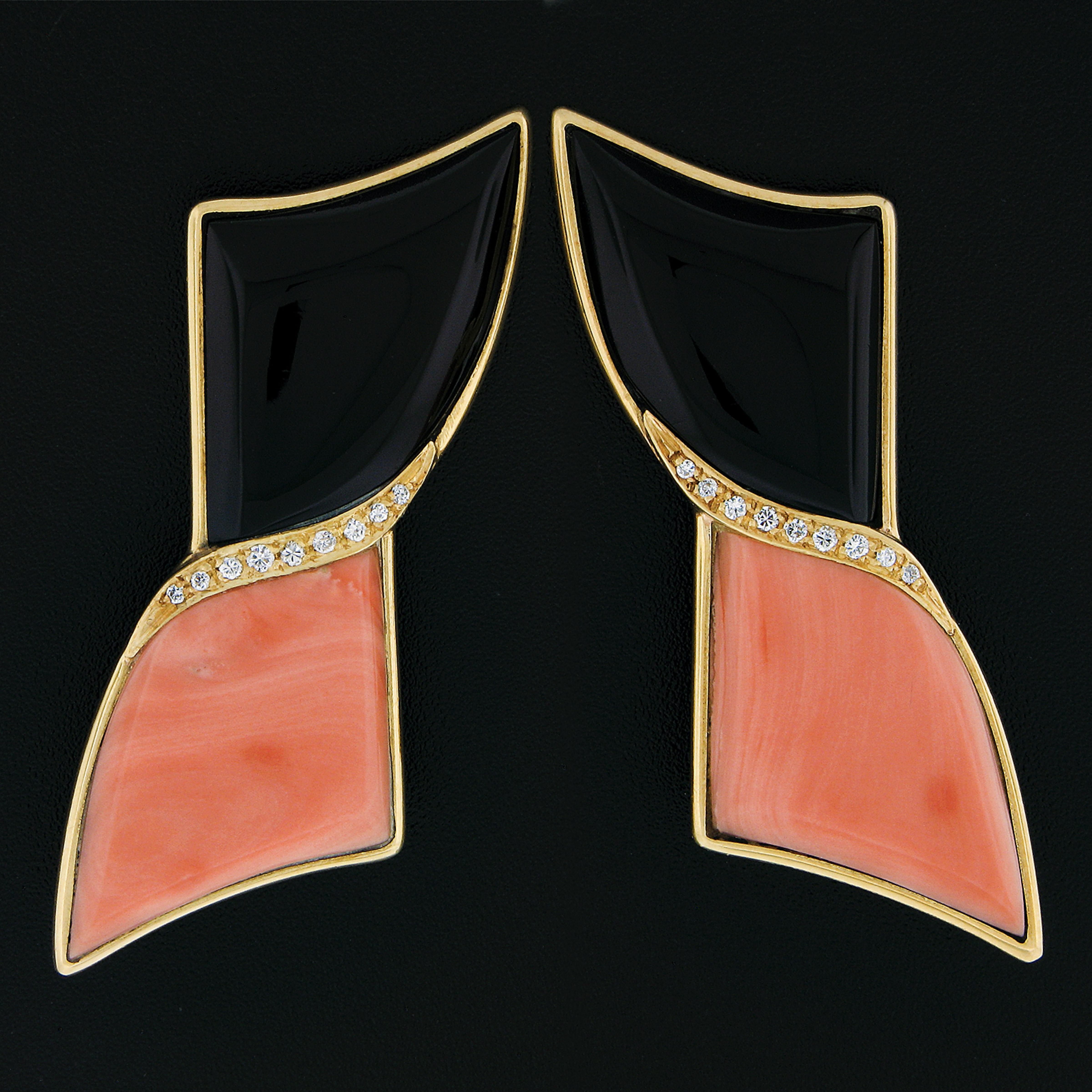 Here we have a large and outstanding pair of vintage statement earrings that are crafted in solid 18k yellow gold and feature natural black onyx and coral stones adorned with fine quality diamond accents. The custom cut black onyx and coral stones