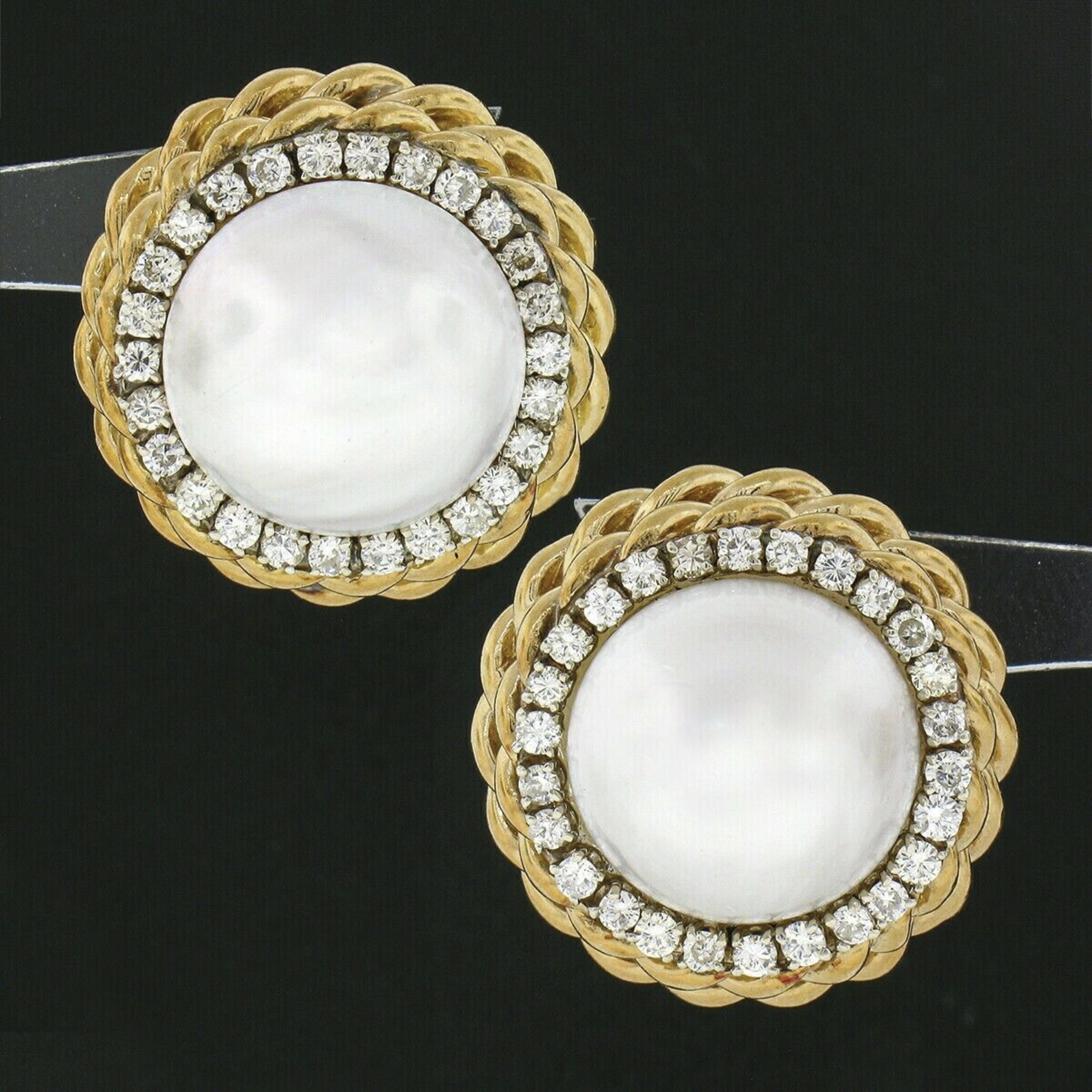 These magnificent and super classy vintage statement earrings are crafted in solid 18k yellow gold. They each feature a large and very nice quality mabe pearl at their center, measuring approximately 15-15.4mm, and display an amazing bright white