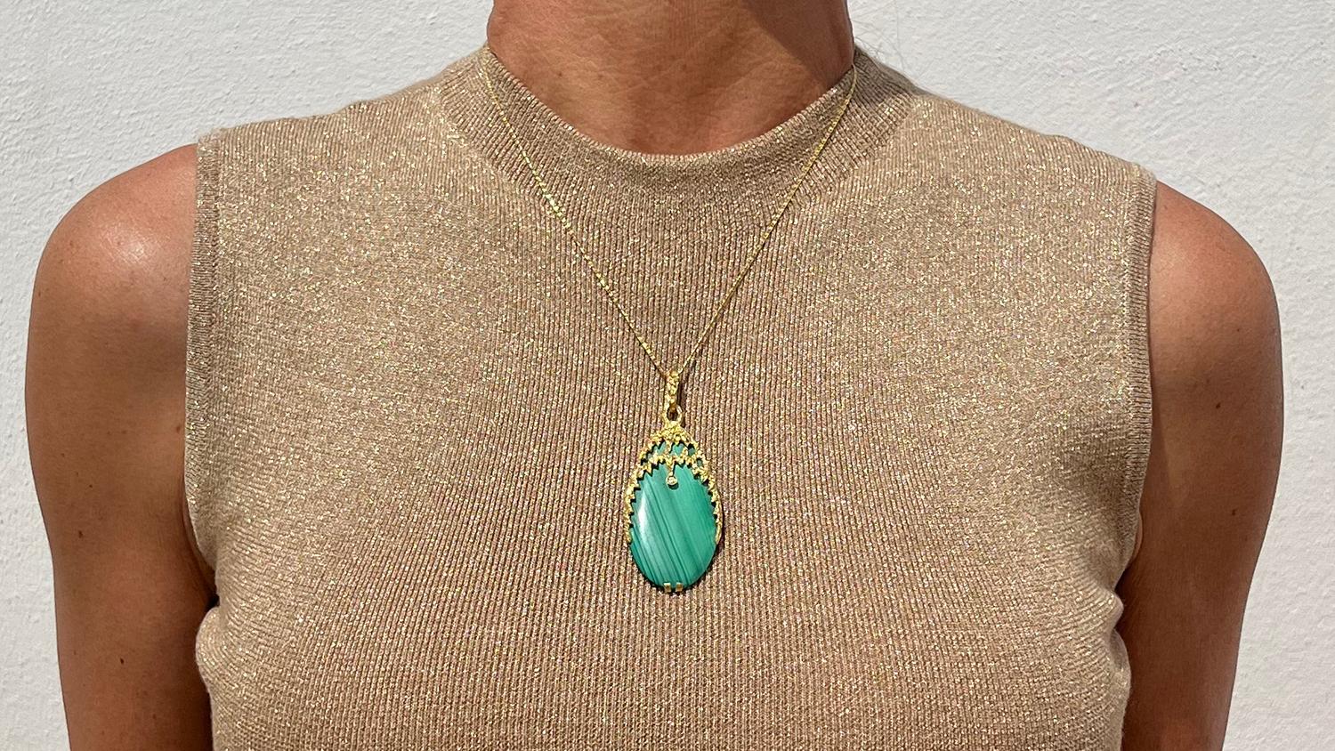 This 18 karat gold, malachite and dimond has a wonderful oval shape. The pendant radiates style and elegance and will be a perfect fit for any occasion.

The pendant has a classic bail which allows a chain to pass through. Please note that the chain