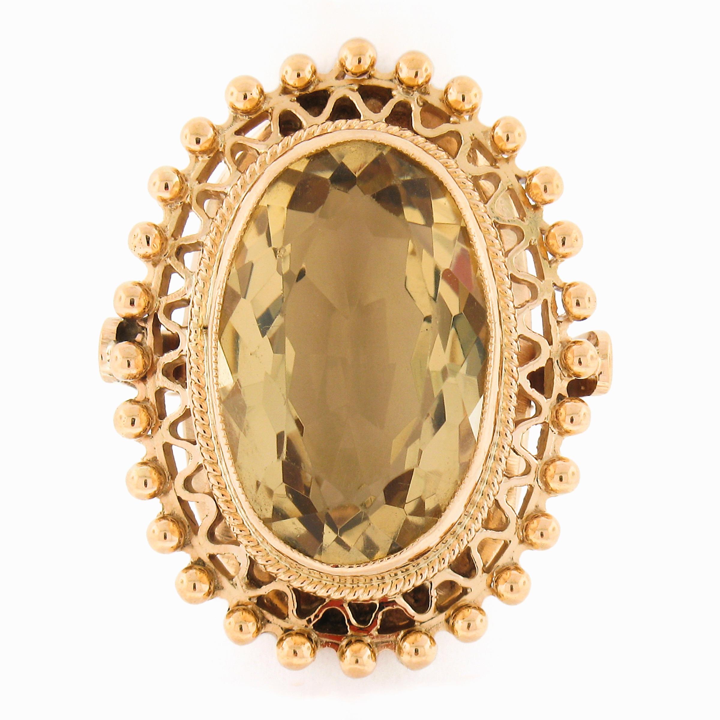 This absolutely gorgeous and well made vintage platter ring is solidly crafted from 18k yellow gold and features a large oval brilliant citrine stone neatly bezel set at its center. The stunning stone is a very fine and fiery golden brown color that