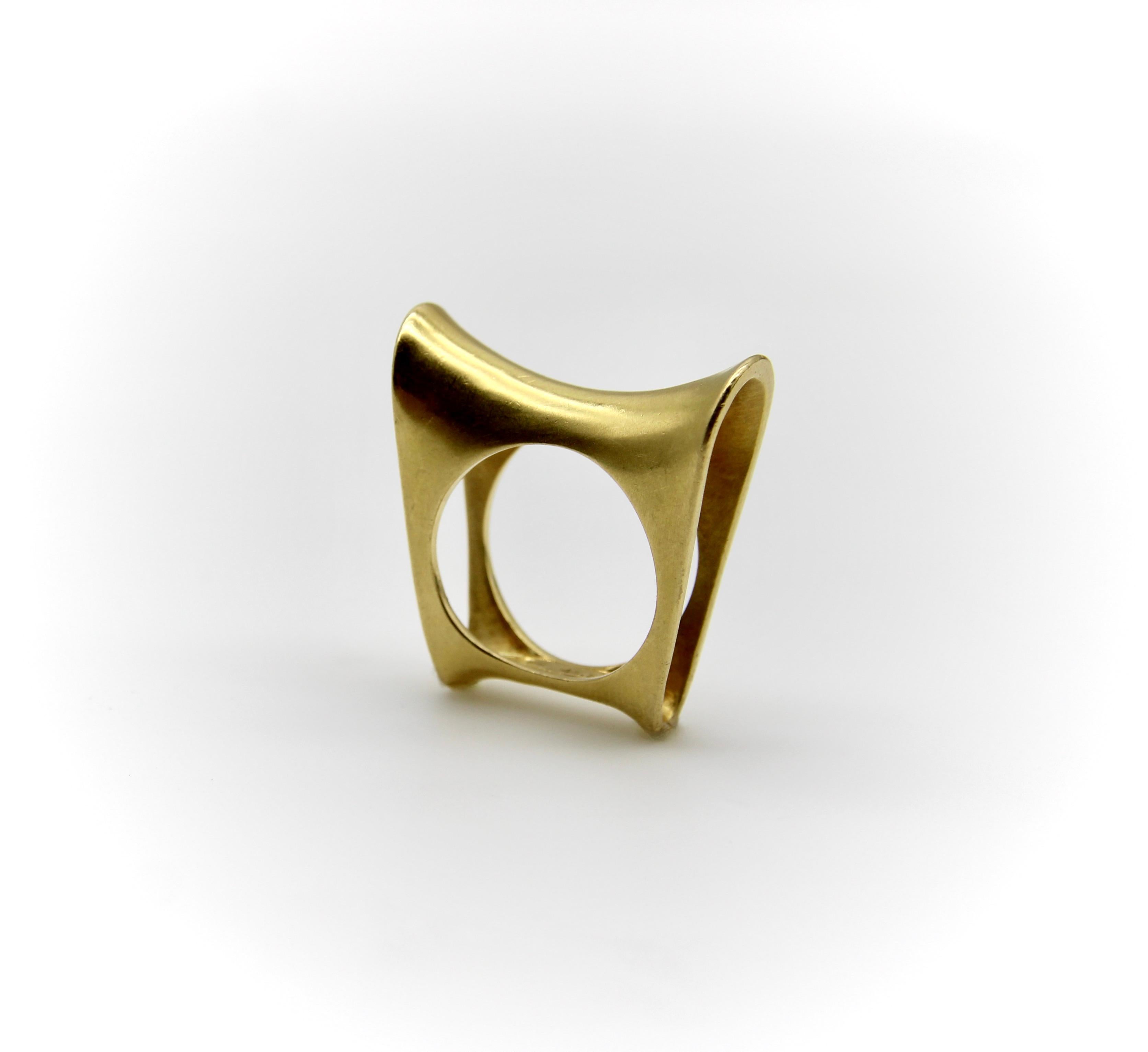 This vintage 18k gold ring is sculptural and bold, with cool, clean lines that are interesting to look at from many different angles. The top of the ring is reminiscent to a saddle, with a scooping concave shape and high profile. From the side, the