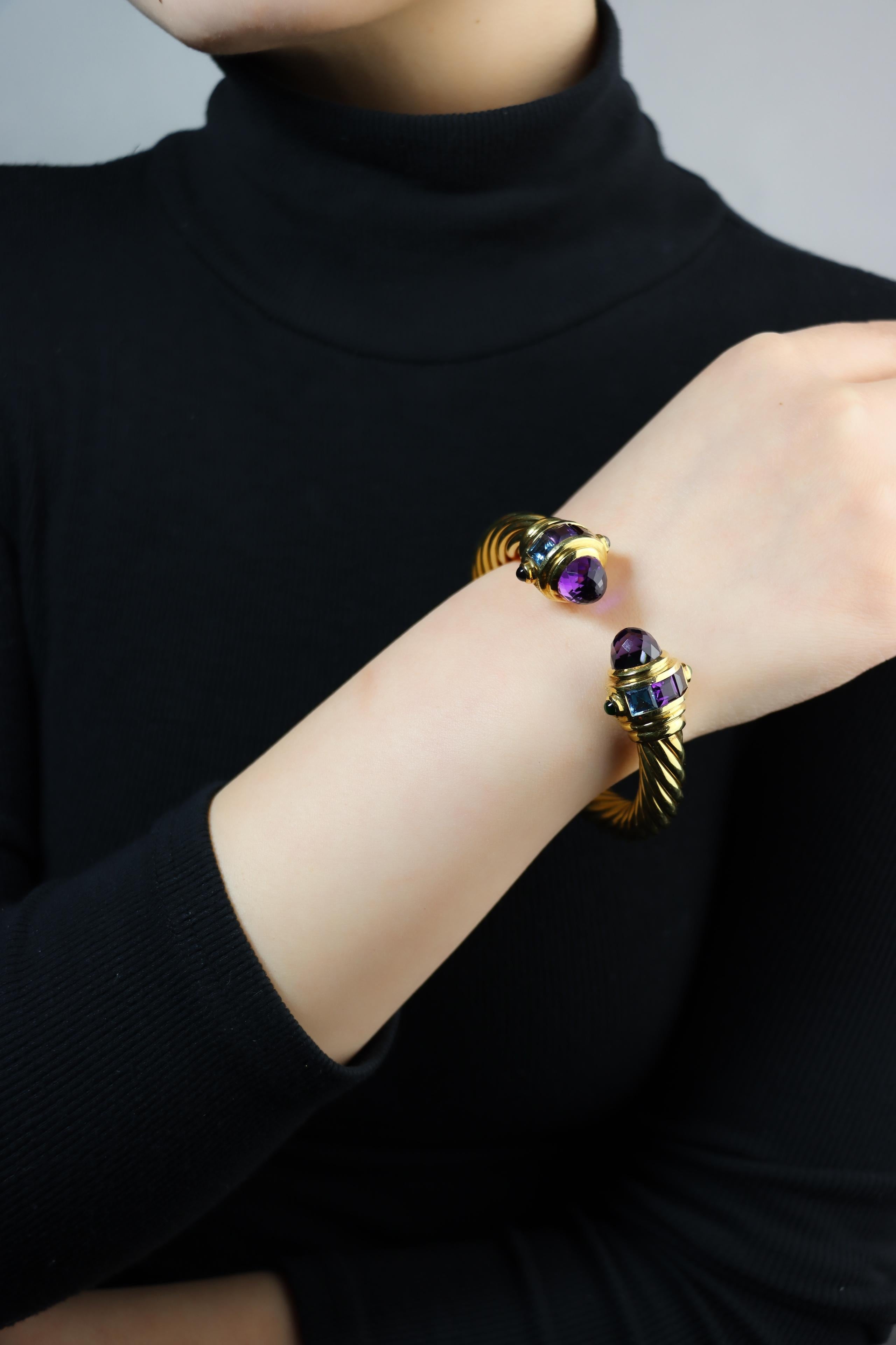 Vintage 18K Gold Muti-Gem Renaissance Cable Bracelet
18K Yellow Gold, Amethyst, Blue Topaz, Garnet, Peridot, Turmaline

Approximate Dimensions:
17 cm (Length) 
0.8 - 1.8 cm (Width)
52.0 grams in weight.