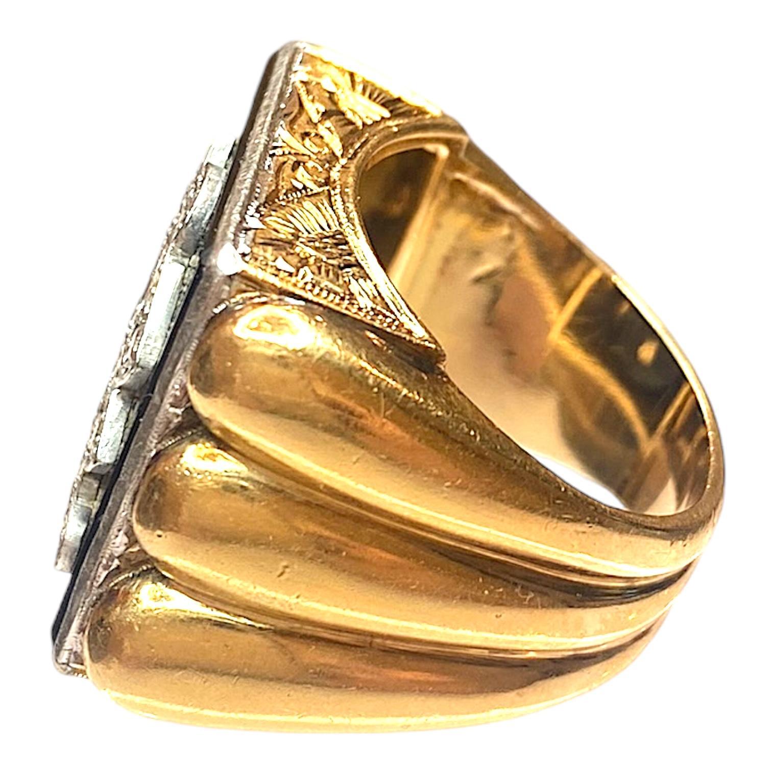 Vintage large hand crafted signet ring in 18K white and yellow gold. The intricate detailing includes a bold, ornate monogram adorned with diamonds set on top of a square cut black onyx, supported by a hand engraved side gallery and scalloped