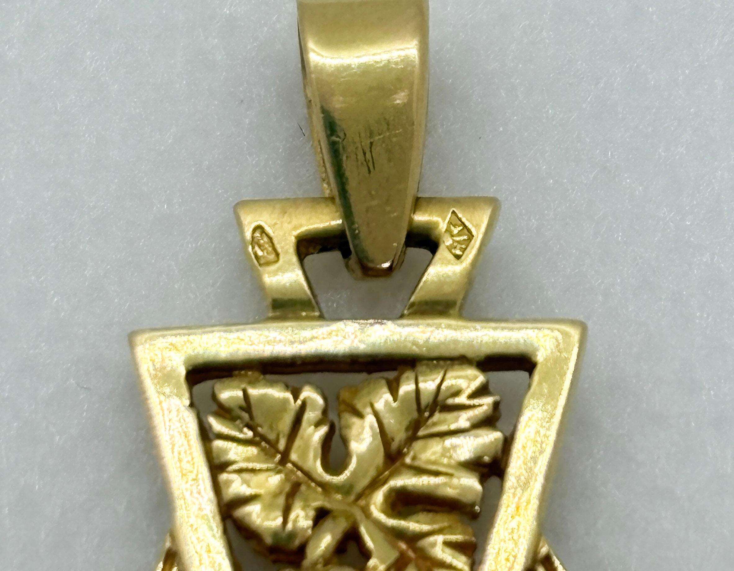 Magnifico ciondolo a croce d'epoca in oro giallo 18 carati, realizzato a mano da un artigiano francese e timbrato con il marchio a testa d'aquila. Questo pezzo grande e intricato (5 × 3,3 cm) mostra un disegno traforato ornato da grappoli d'uva e