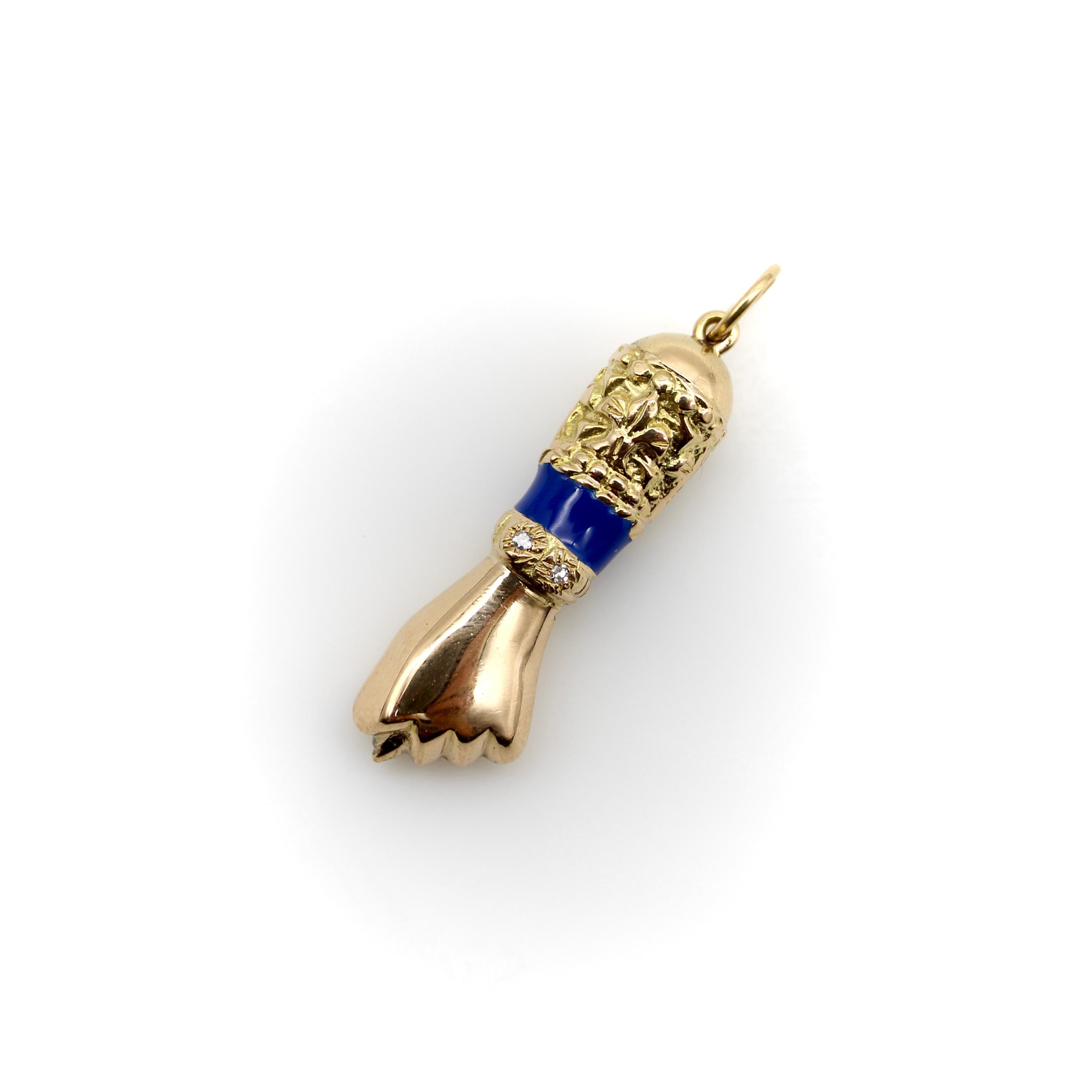 Questo pendente Figa è realizzato in oro massiccio 18 carati, ornato con smalto blu e due diamanti a taglio singolo. Il pugno chiuso con il pollice esteso tra due dita è un simbolo di femminilità in molte culture. La cosa più nota è che in Brasile