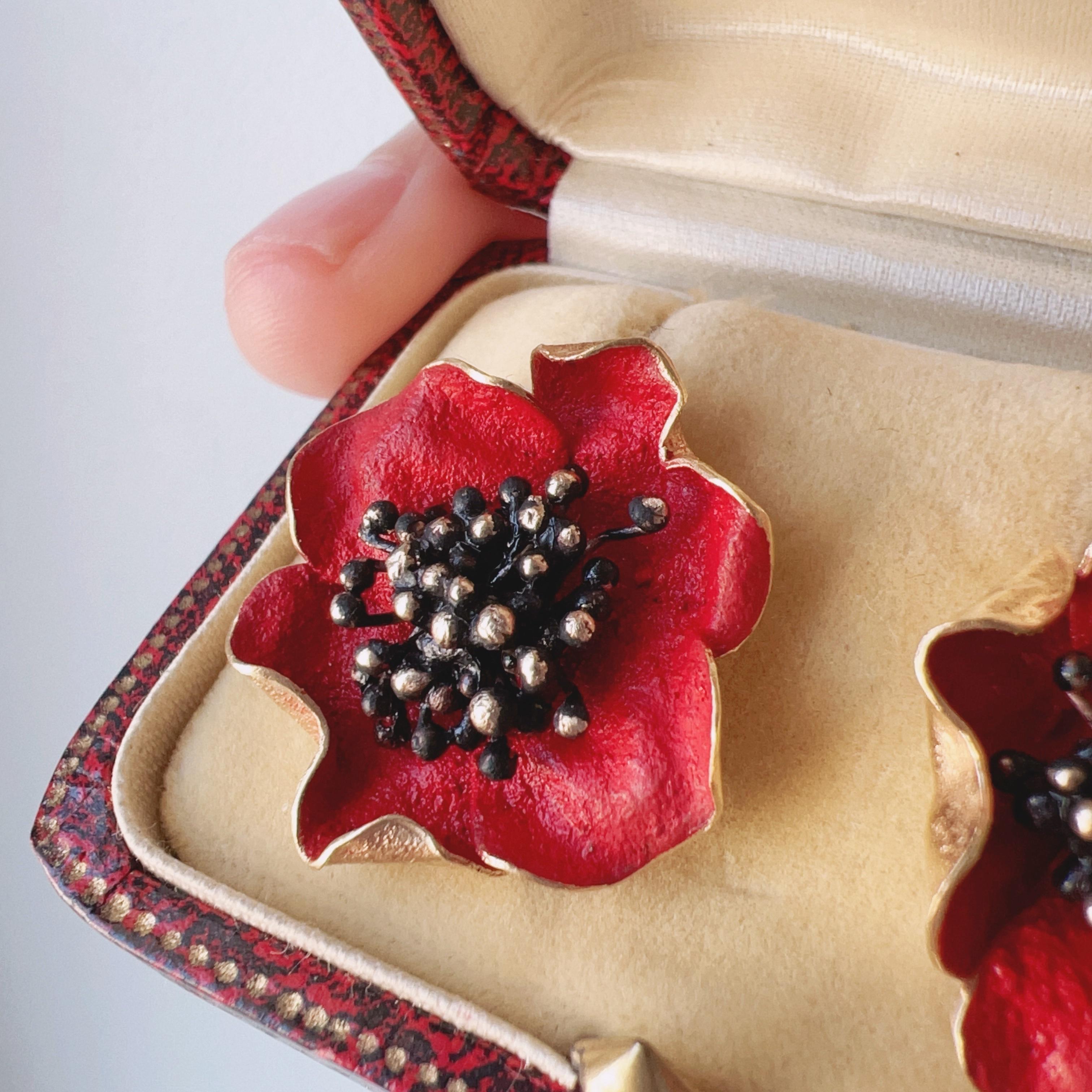 Indulge in the timeless elegance of nature's allure with these beautiful 18K gold poppy flower earrings. Crafted with meticulous attention to detail, each earring features a delicate poppy bloom, intricately adorned with vibrant red enamel on the