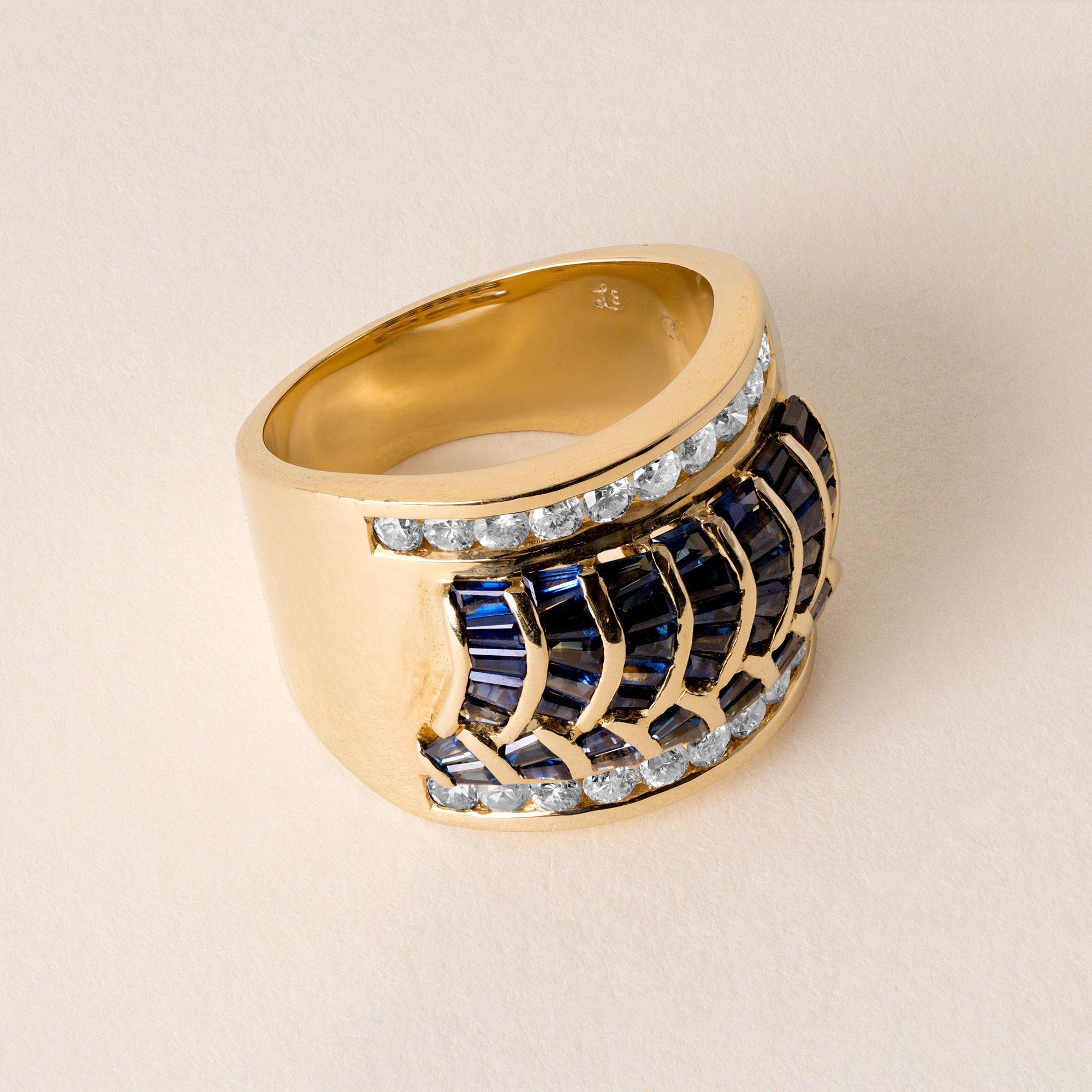Il s'agit d'une bague vintage en 18 carats ornée de saphirs bleus et de diamants.
serti dans un large anneau d'or.
Circa 1980's
Détails :
49 saphirs baguettes effilés pèsent ~1,50 carats
dans un motif de vagues encadré par des
20 diamants ronds de