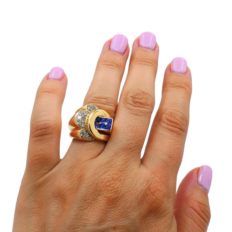 

Questo anello vintage è realizzato in oro giallo 18 carati ed è un pezzo di grande effetto. Il design audace e scultoreo presenta un grappolo geometrico di vibranti zaffiri blu a taglio quadrato al centro, creando un accattivante punto focale.