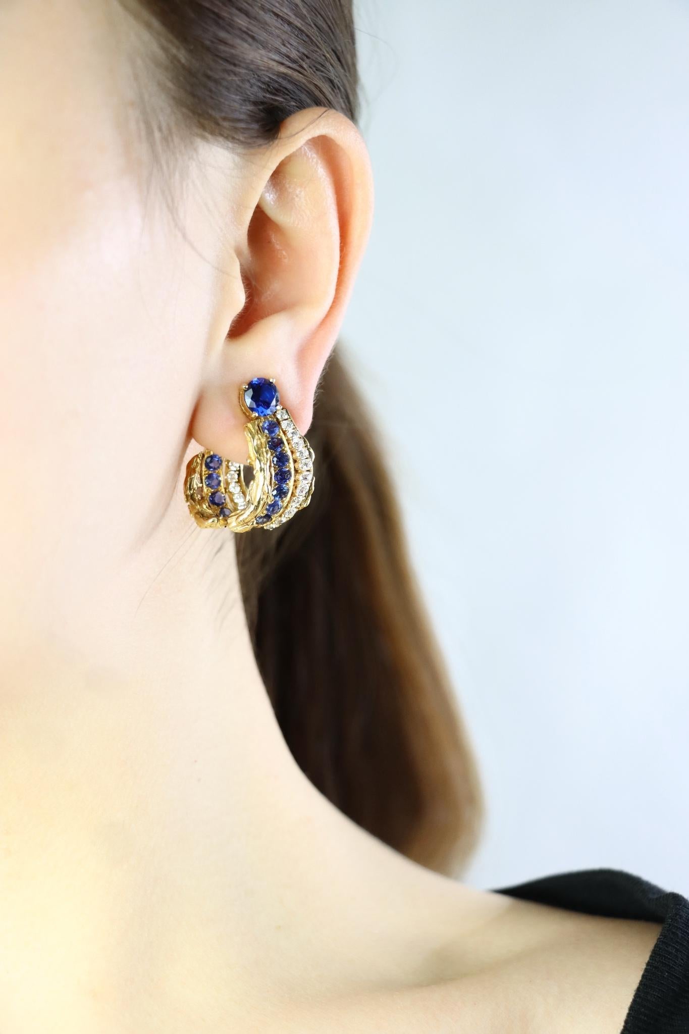 A Vintage Pair of 18k Gold Spinel Sapphire Diamond Inside Out Hoop Earrings
Featuring 2.5 Carats of Blue Round Spinels and the hoops accented with approximately 1.70 Carats of Diamonds and 1.10 Carats of Sapphires. 

Approximate Dimensions:
2.8 cm