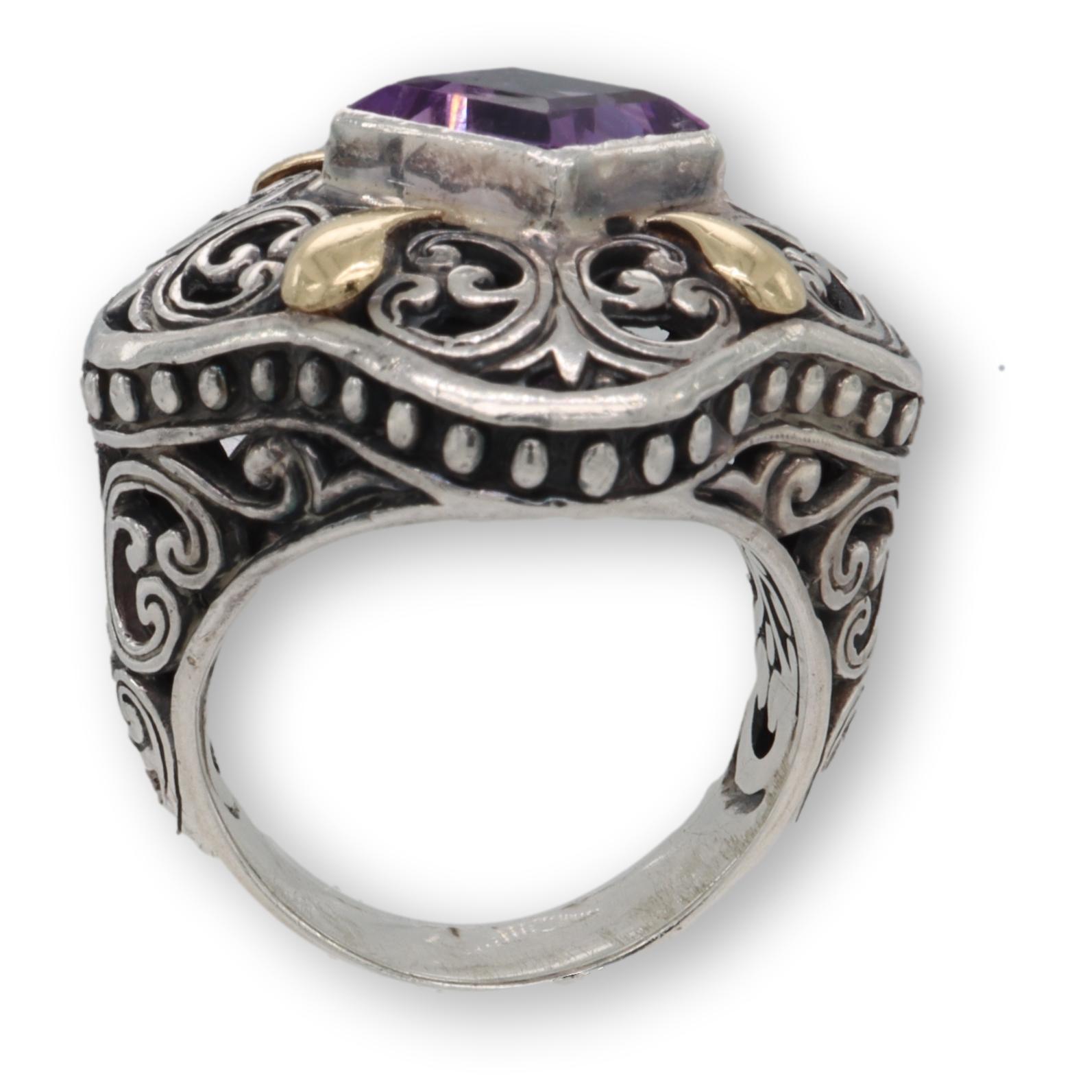 Vintage cocktail ring finely crafted in blackened sterling silver with 18 karat yellow gold accents featuring a square shape amethyst set in a bezel. The ring has a chunky feel. and measures 25mm at all sides on the top. Scrollwork details are all