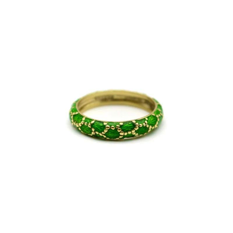 Hailing from the 1960’s, this vintage Tiffany & Co. ring makes a splash! Gorgeous green enamel floats in an 18k gold dotted motif. The ring is vibrant: carved gold shines through the enamel for a visual texture reminiscent of fish scales, and the