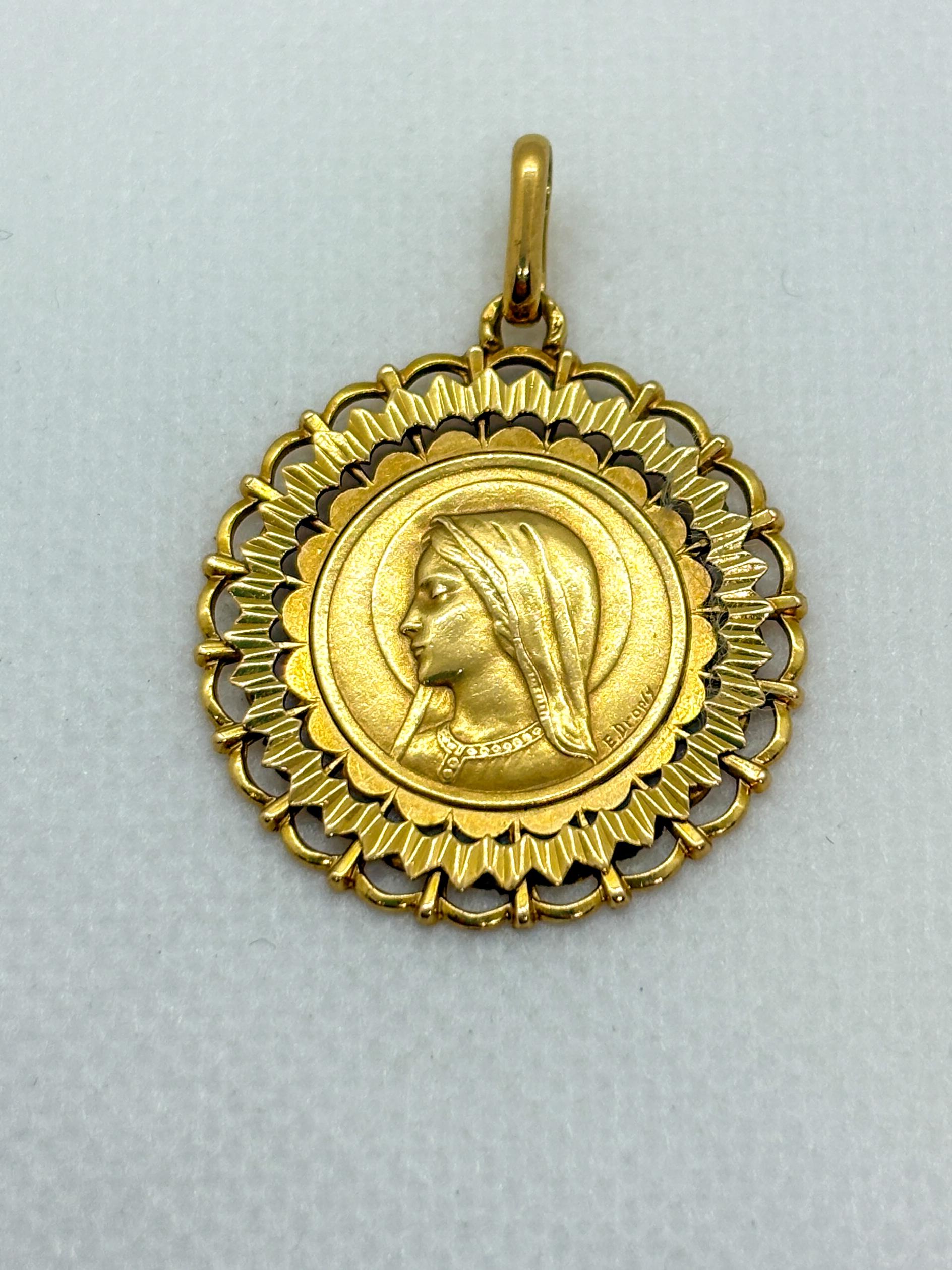 Bellissimo pendente della Vergine Maria in oro giallo 18k disegnato da Émile Dropsy, uno dei più stimati medaglisti francesi dell'inizio del XX secolo. Il dritto presenta un sereno profilo della Vergine finemente scolpito in rilievo, con la firma di