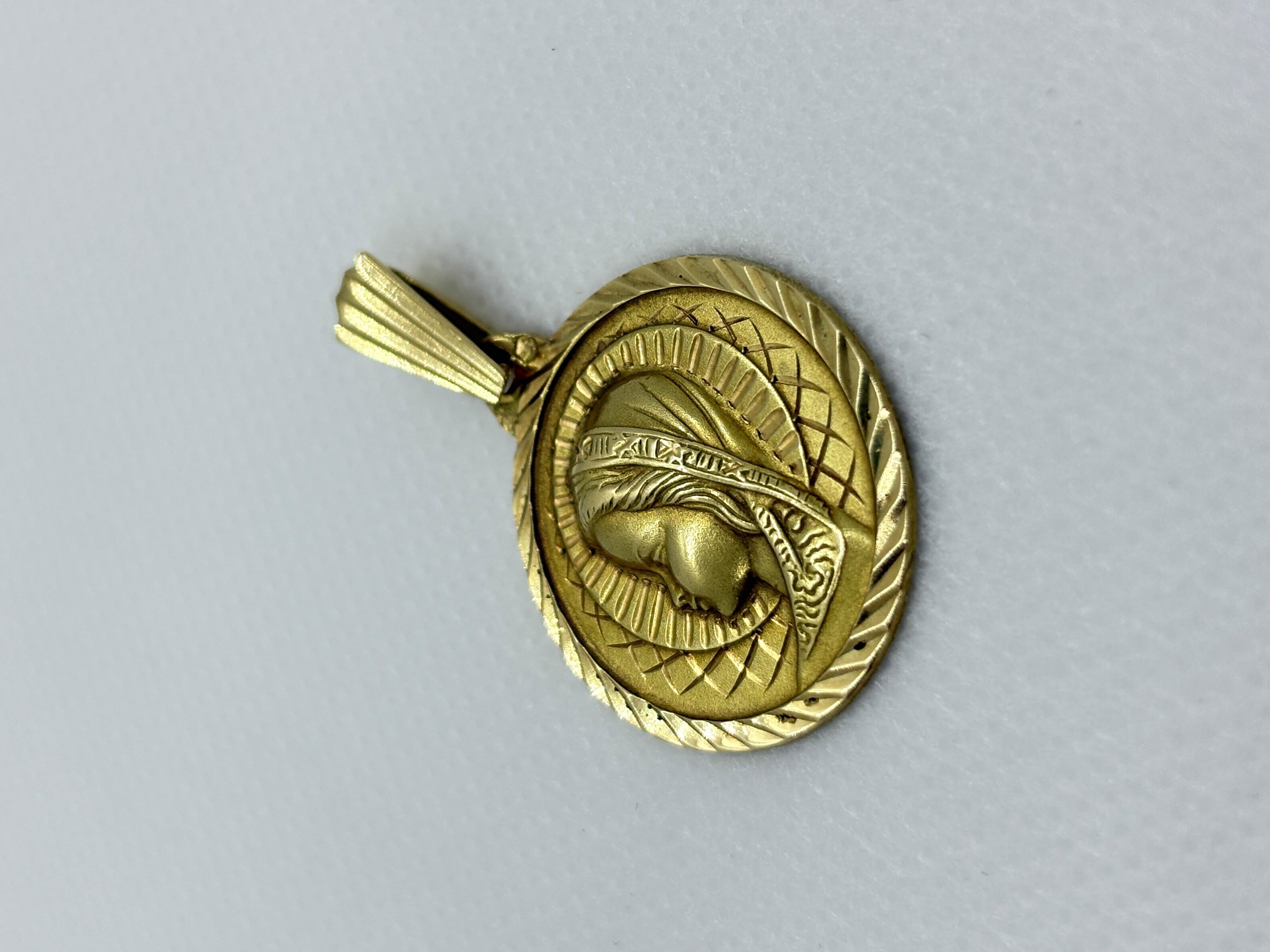 Elegante ciondolo vintage in oro giallo 18k con un profilo dettagliato della Vergine Maria. Realizzata in Francia alla fine del XX secolo, questa medaglia combina una raffinata incisione con un bordo sfaccettato che riflette magnificamente la luce.