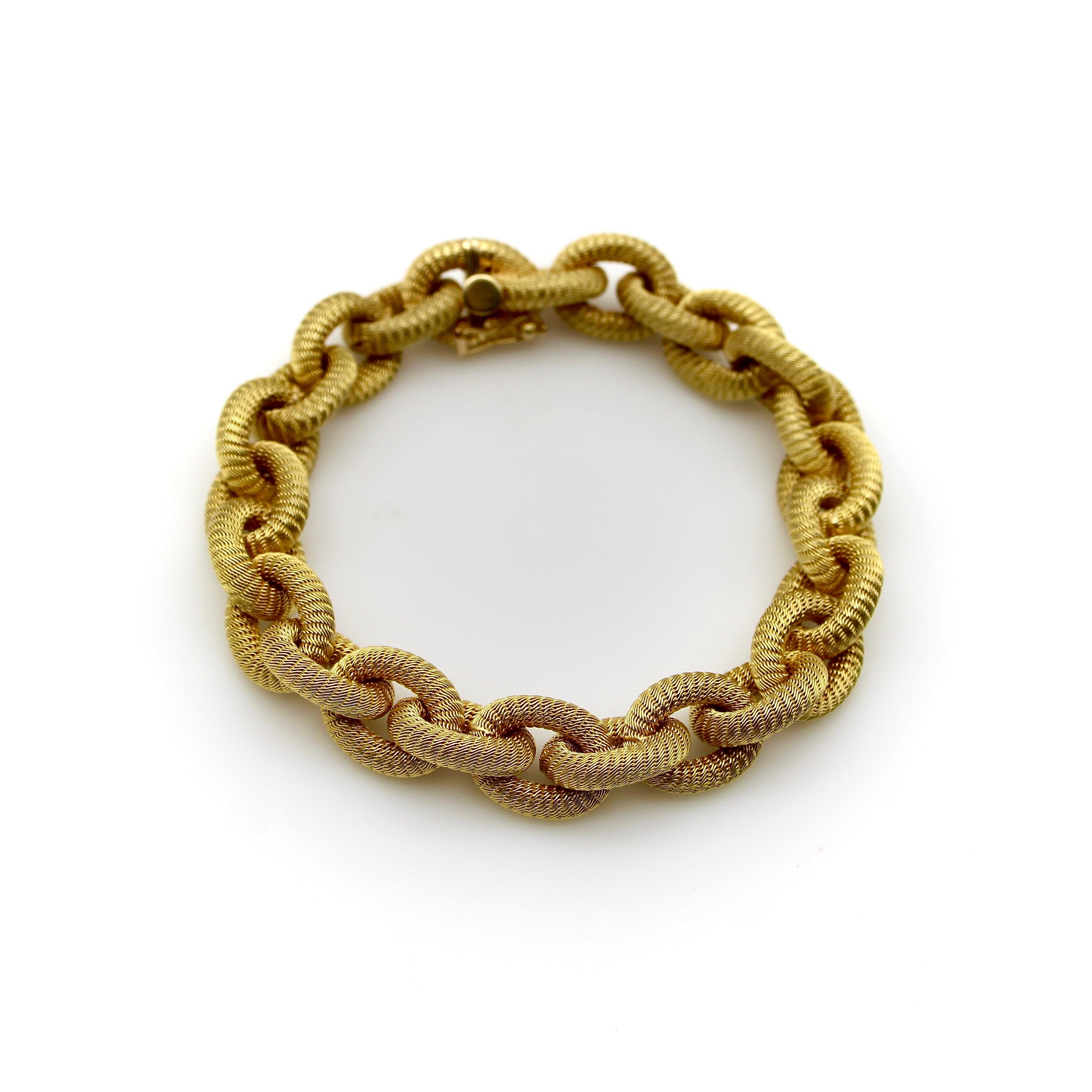 Indicative of a classic French woven bracelet, this stunning piece is extremely well-crafted. Its hand-woven oval links are meticulously detailed, each painstakingly looped to create an intricate, delicate effect that shimmers like matte gold. The