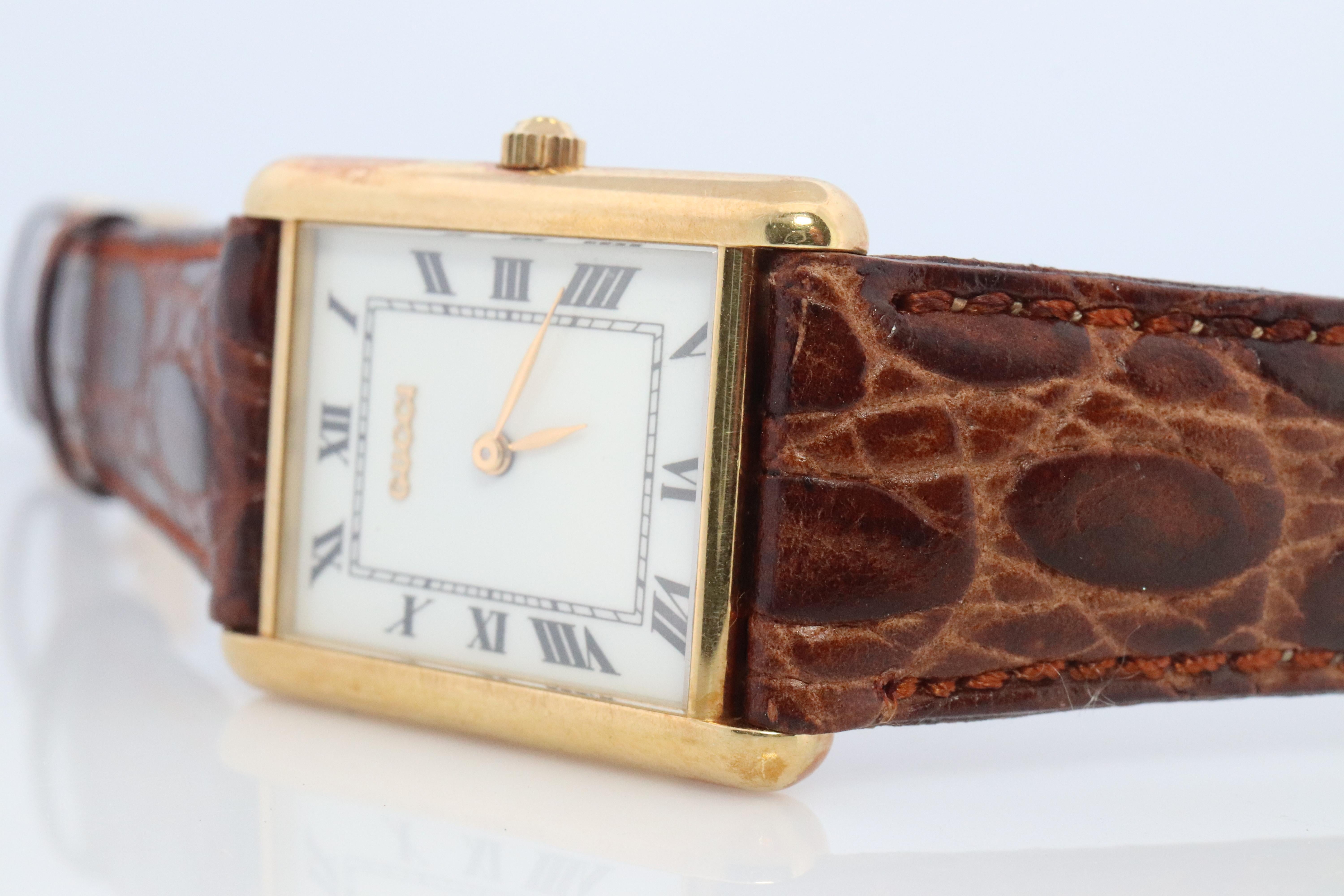 Echte Gucci 710L Tank-Armbanduhr.
18k 750 Gelbgold massiv Gehäuse.

Kommt mit Original GUCCI BOX und Original-Papierkram mit Gucci International Guarantee Card.

Weißes Zifferblatt mit römischen Ziffern.

Herren, kann aber auch Unisex
