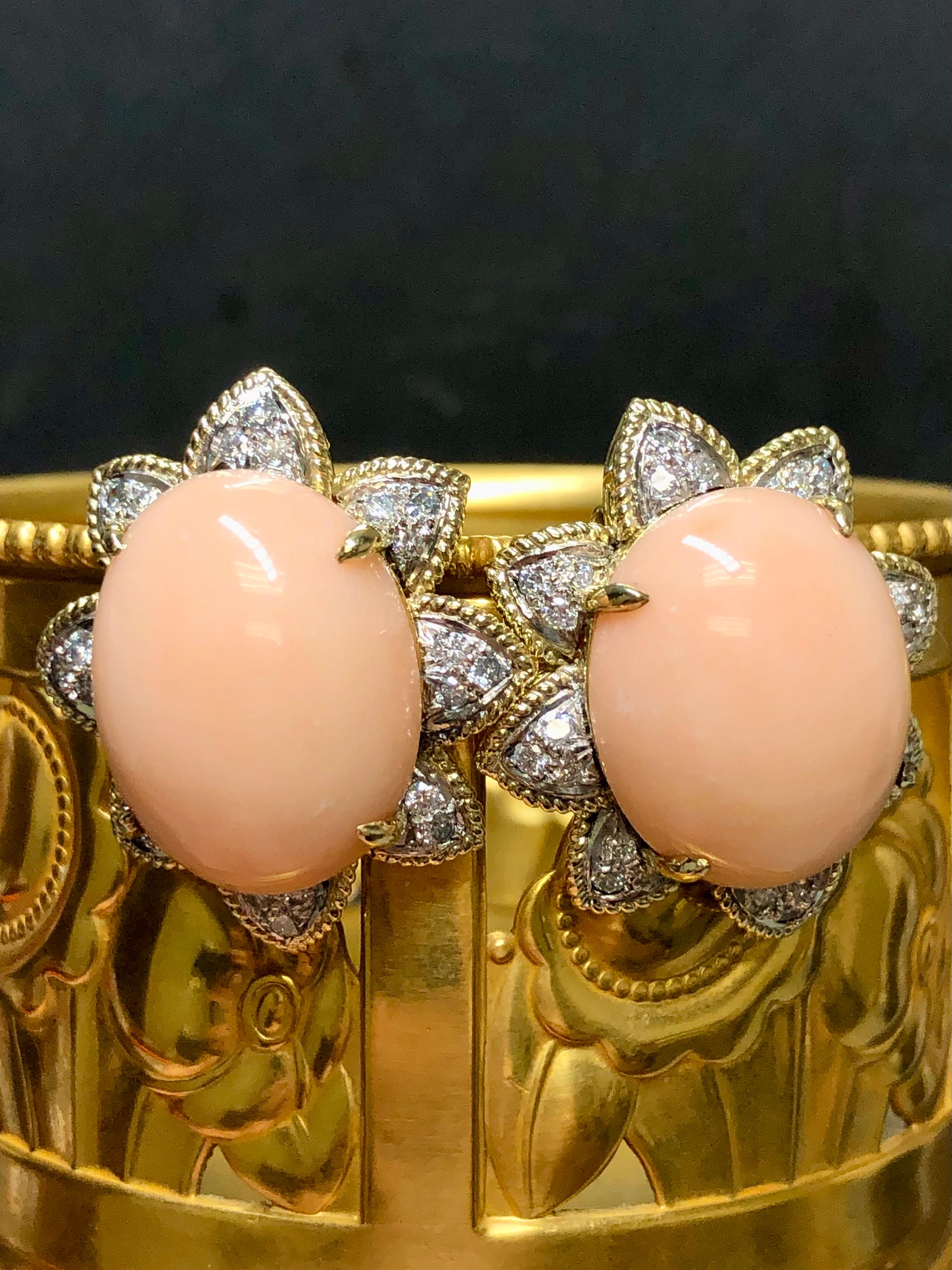 A vintage pair of earrings c. 1960’s done in 18K and centered by large oval coral cabochons (22mm x 17.4m) surrounded by approximately .96cttw in G-I color Va1-SI1 round diamonds. Posts can be added for pierced ears. Classic 60’s jewelry never goes