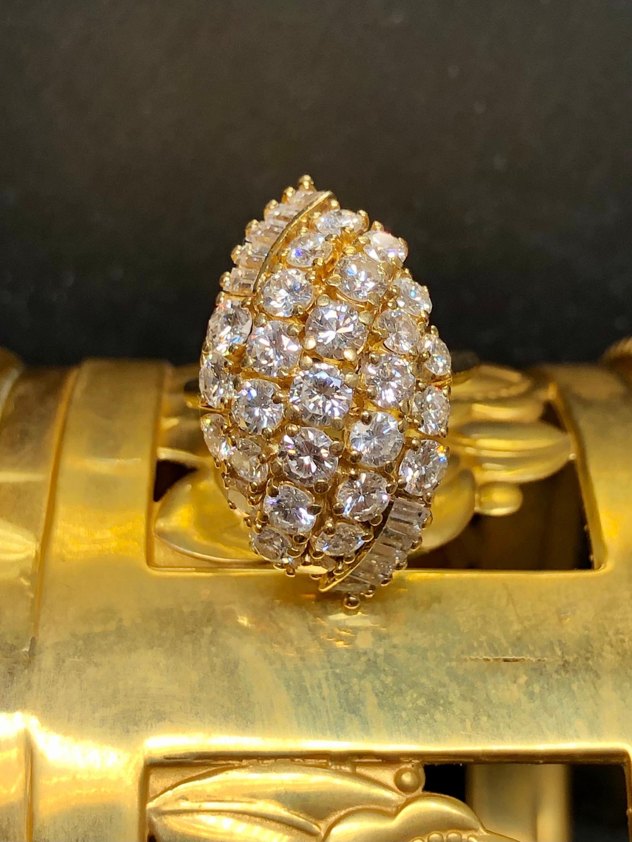 A gorgeously done vintage cocktail ring done in 18K yellow gold and prong set with approximately 3.65cttw in F-G color Vs1-2 clarity larger round and baguette diamonds.


Condition:

All stones are securely set and in perfectly wearable