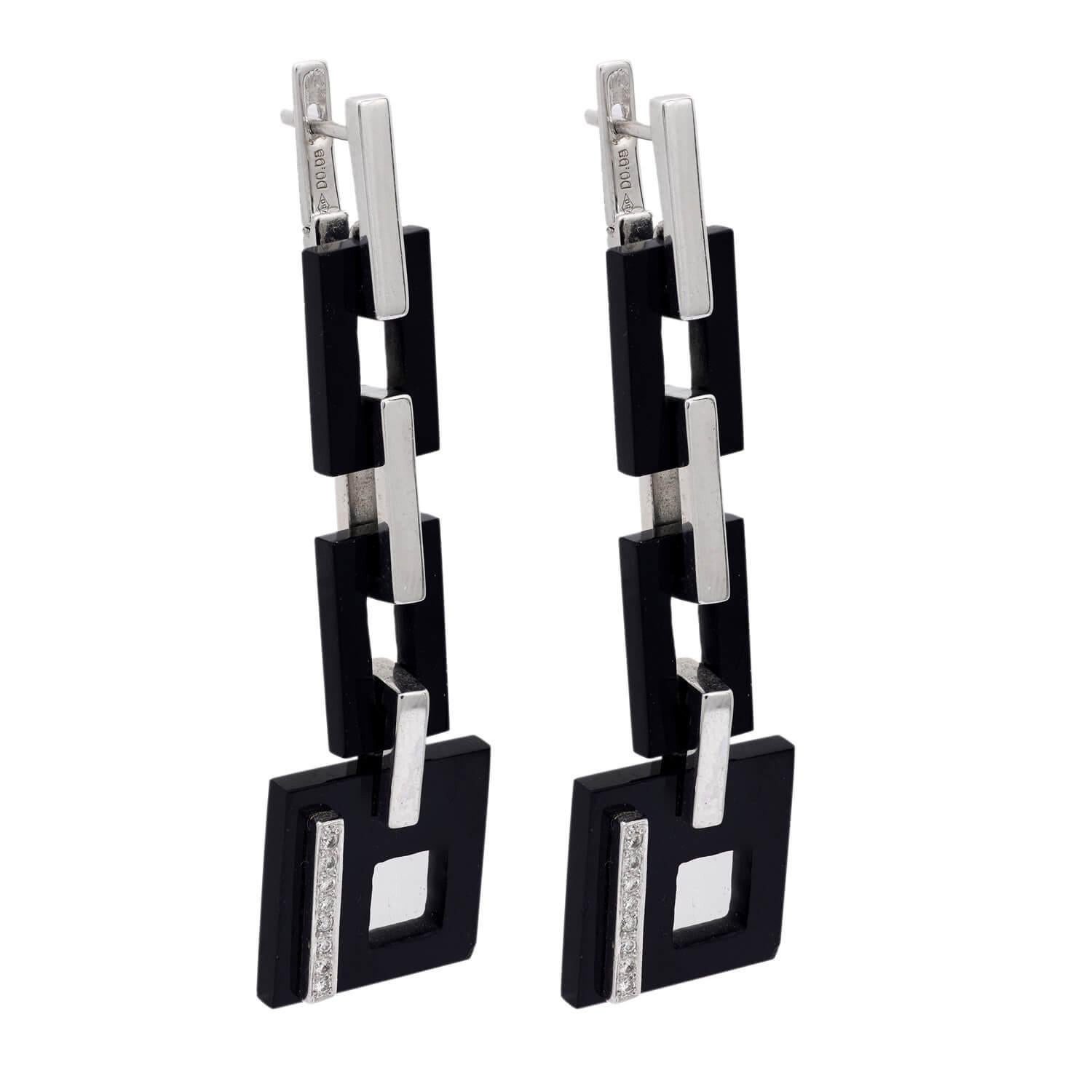 Fantastic onyx and diamond earrings from the Vintage (ca1970s) era! Crafted in 18k white gold, these earrings are comprised of rectangular links. The links alternate between smooth platinum and dark onyx. The lowest link of the earrings is