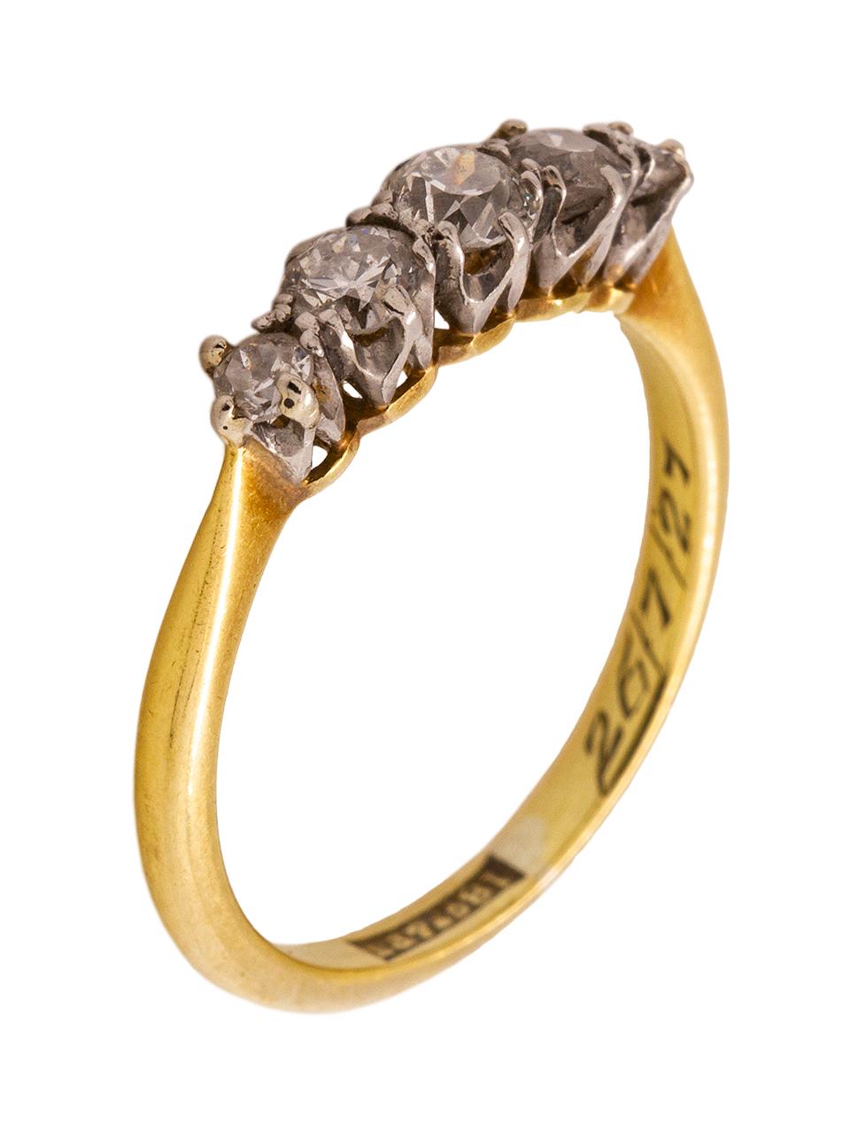 This vintage 18k yellow gold and platinum five stone diamond ring was most likely made in Europe, as denoted by the deep hallmark inside the shank and engraved date of 26/7/27, which is accompanied by engraved initials that appear to read 