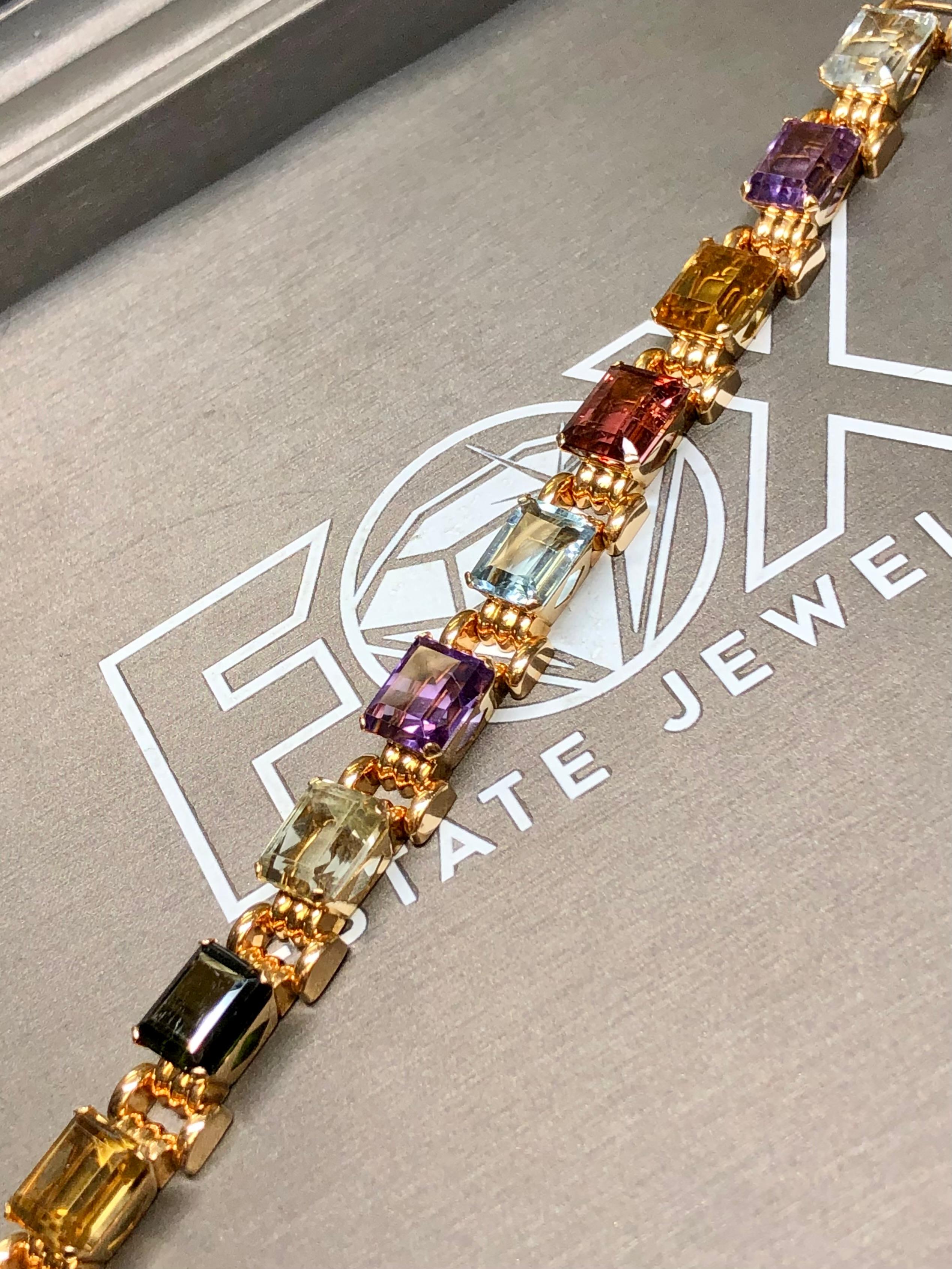 
A bright and colorful mid-century bracelet hand done in 18K rose gold and prong set with large emerald cut aquamarine, tourmaline amethyst and citrine gemstones. All stones average approximately 5ct with the total weight being