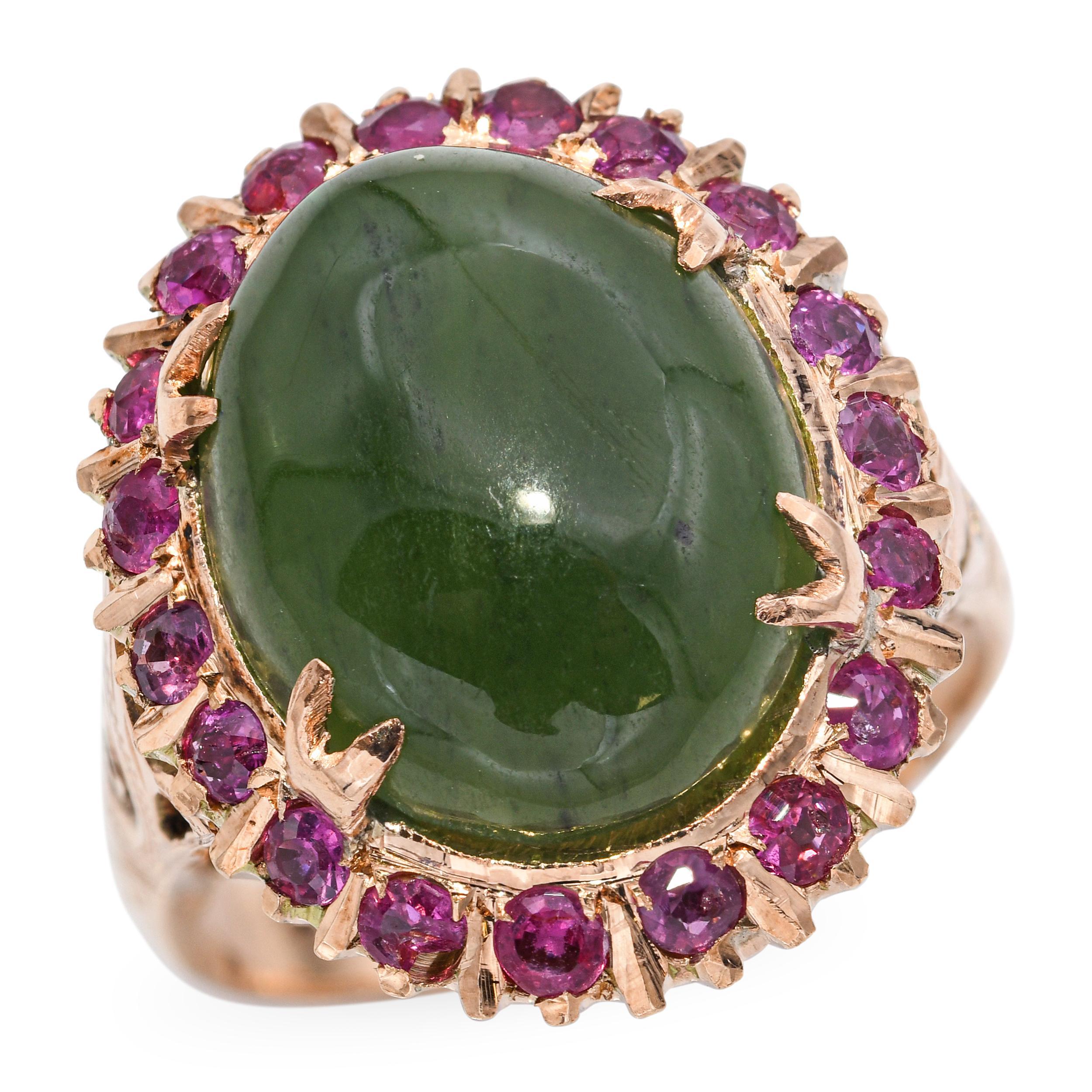 This vintage 18k rose gold ring showcases a richly hued 7.86ct oval nephrite jade, framed in a vivid halo of approximately 0.60tcw natural rubies. The warm tone of the rose gold complements the deep green of the jade and the bright pink-red of the