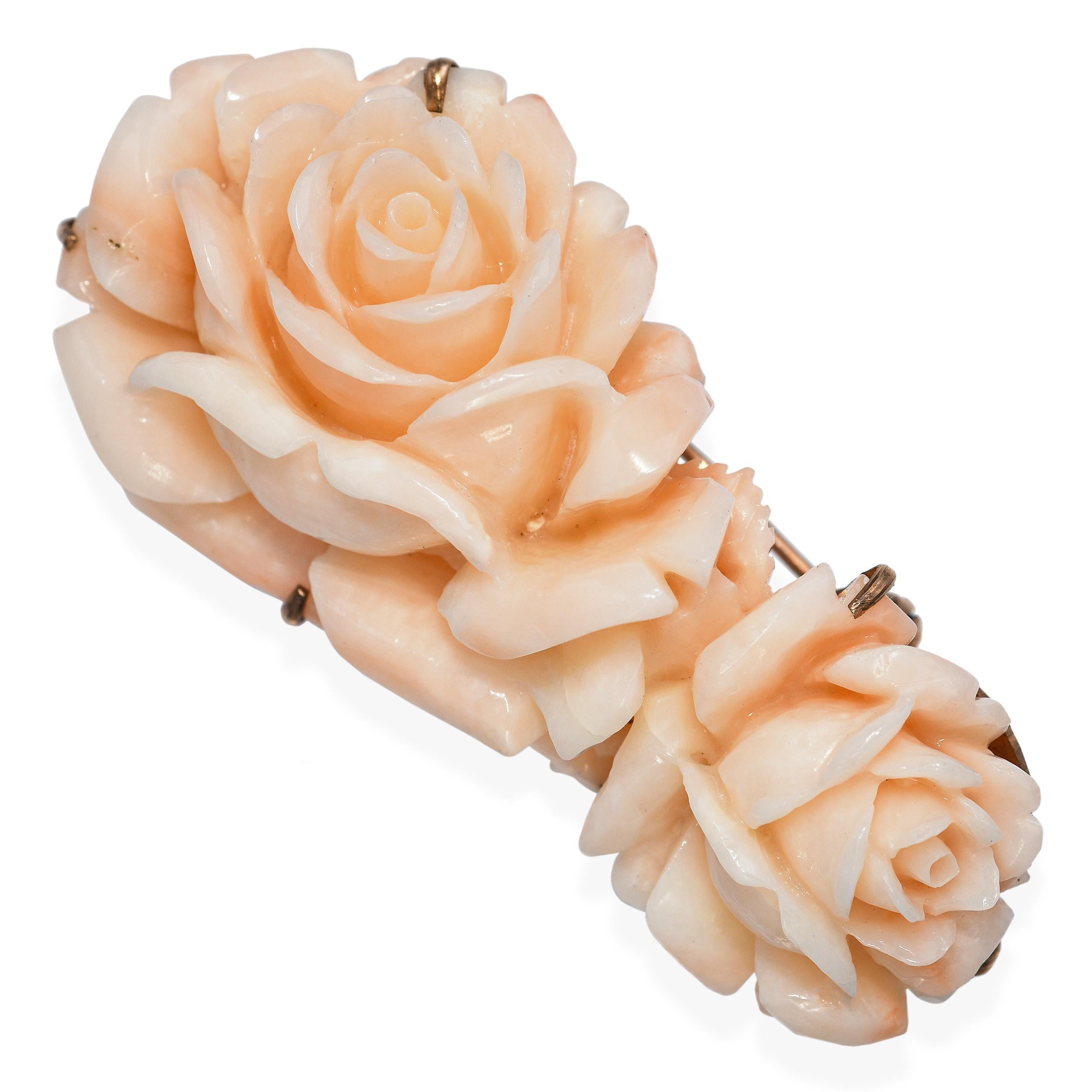 This vintage piece is crafted in warm 18k rose gold and features a delicately carved angel skin coral rose, prized for its soft blush hue and intricate detail. The natural coral is expertly shaped into lifelike petals, showcasing the artisan’s skill